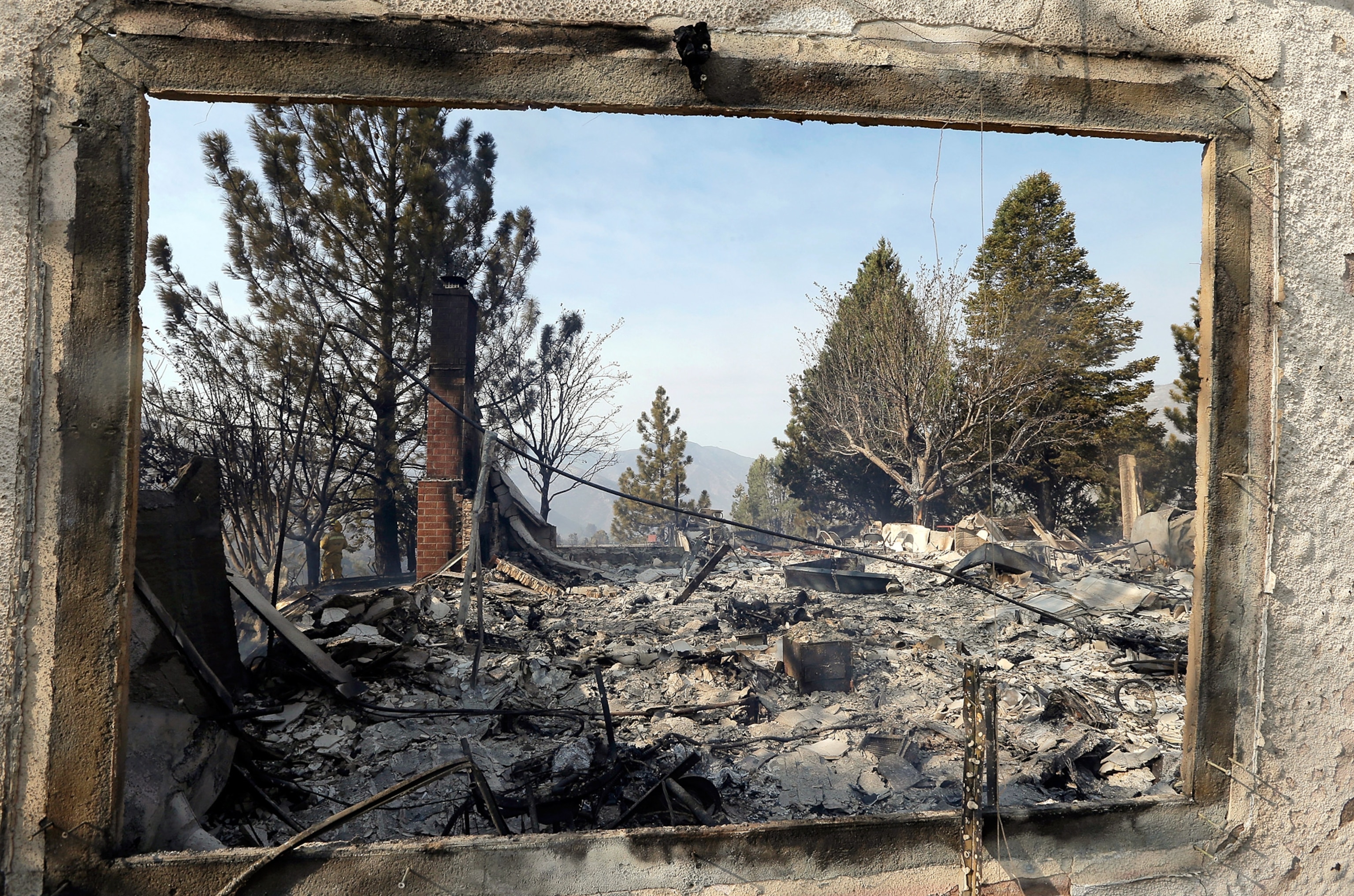 destruction through the window frame of a burned down home