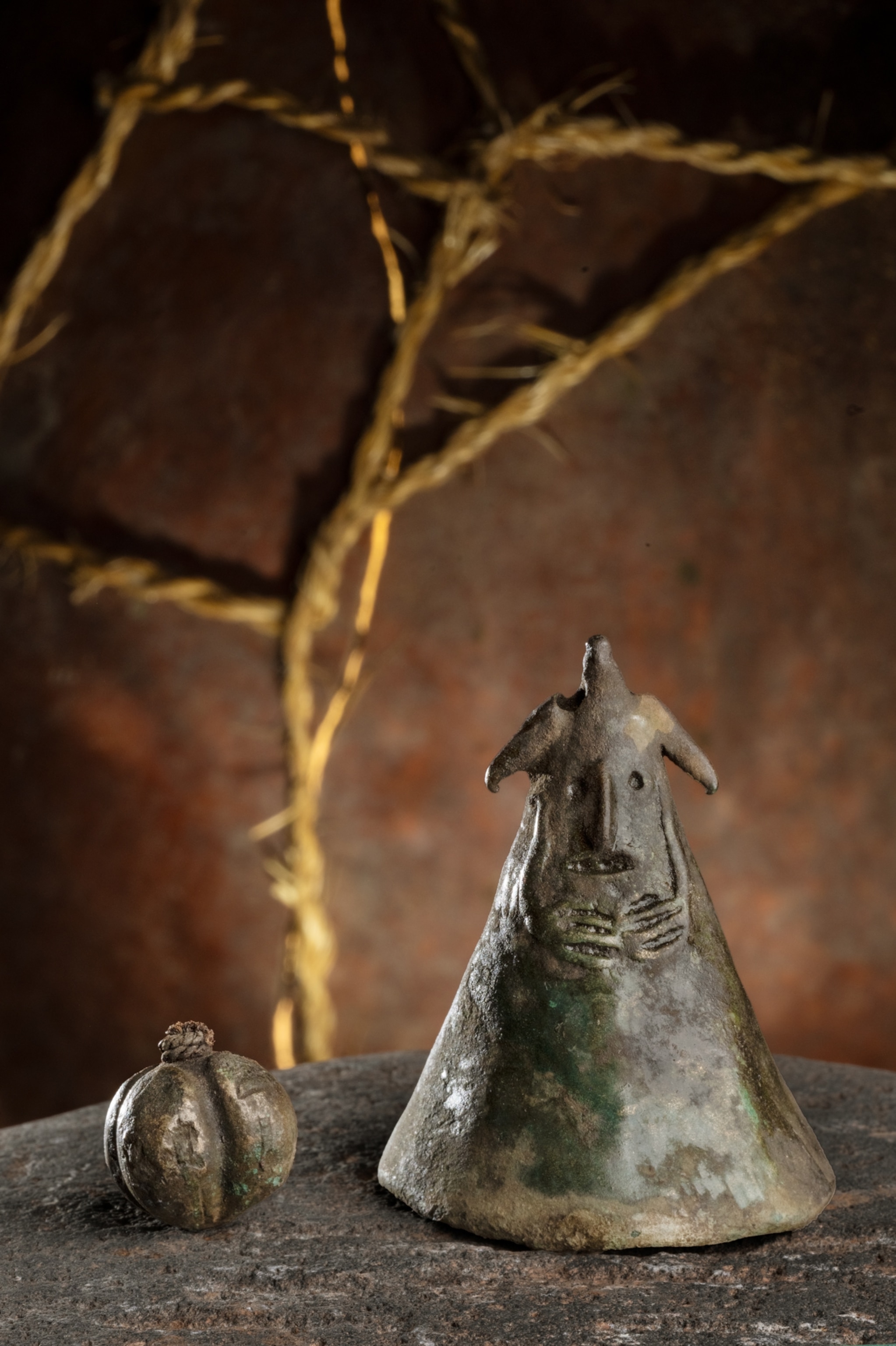 The conical bell is decorated with a complex sculptural composition