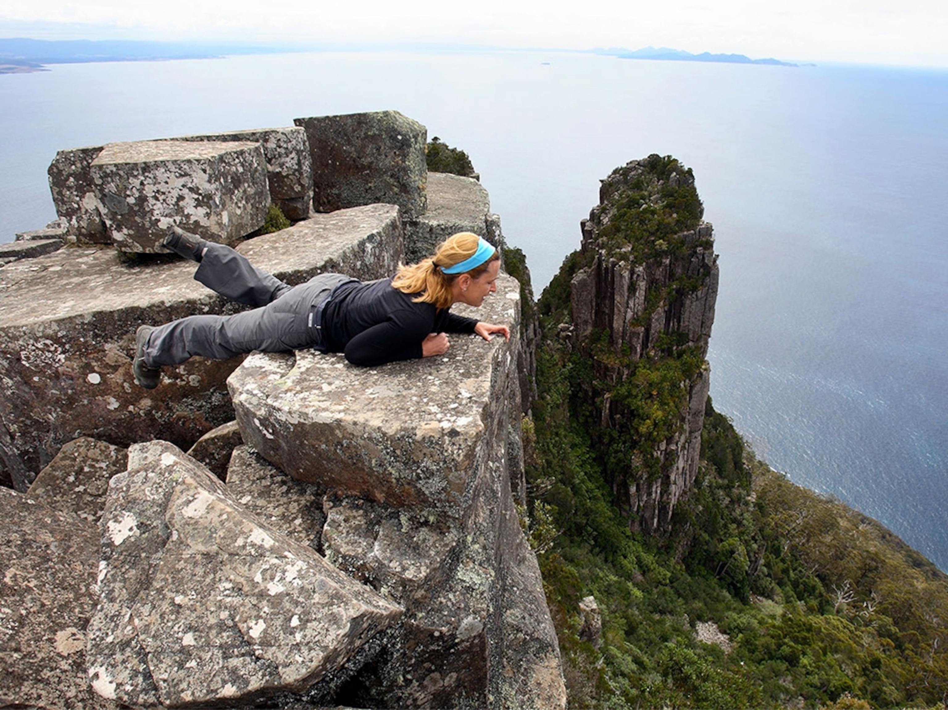 a woman looking over a cliff on Maria Island in Tasmania, Australia