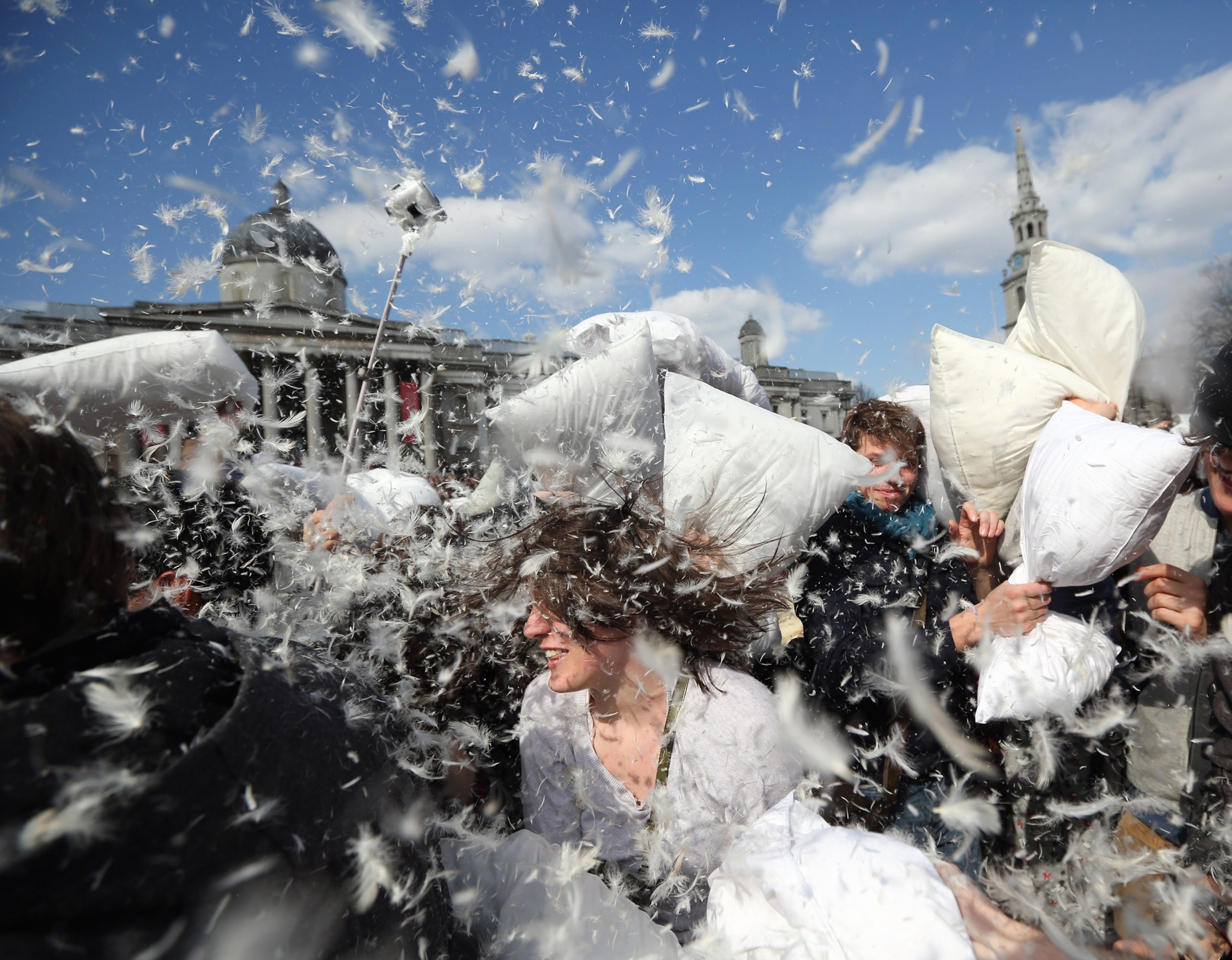 People fight with pillows in Trafalgar Square, London, England.