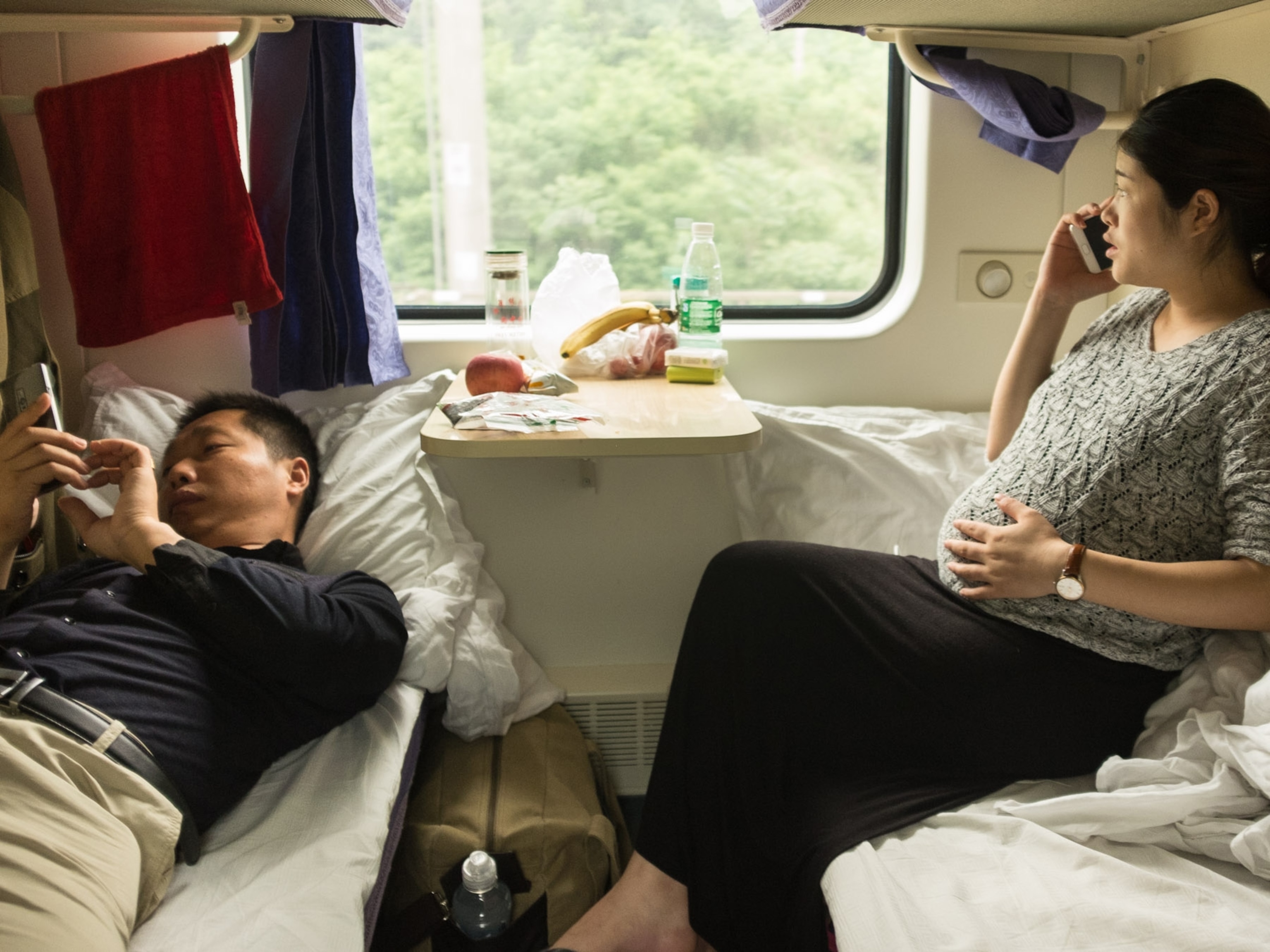 a pregnant woman chats with her mom while her husband catches up on work