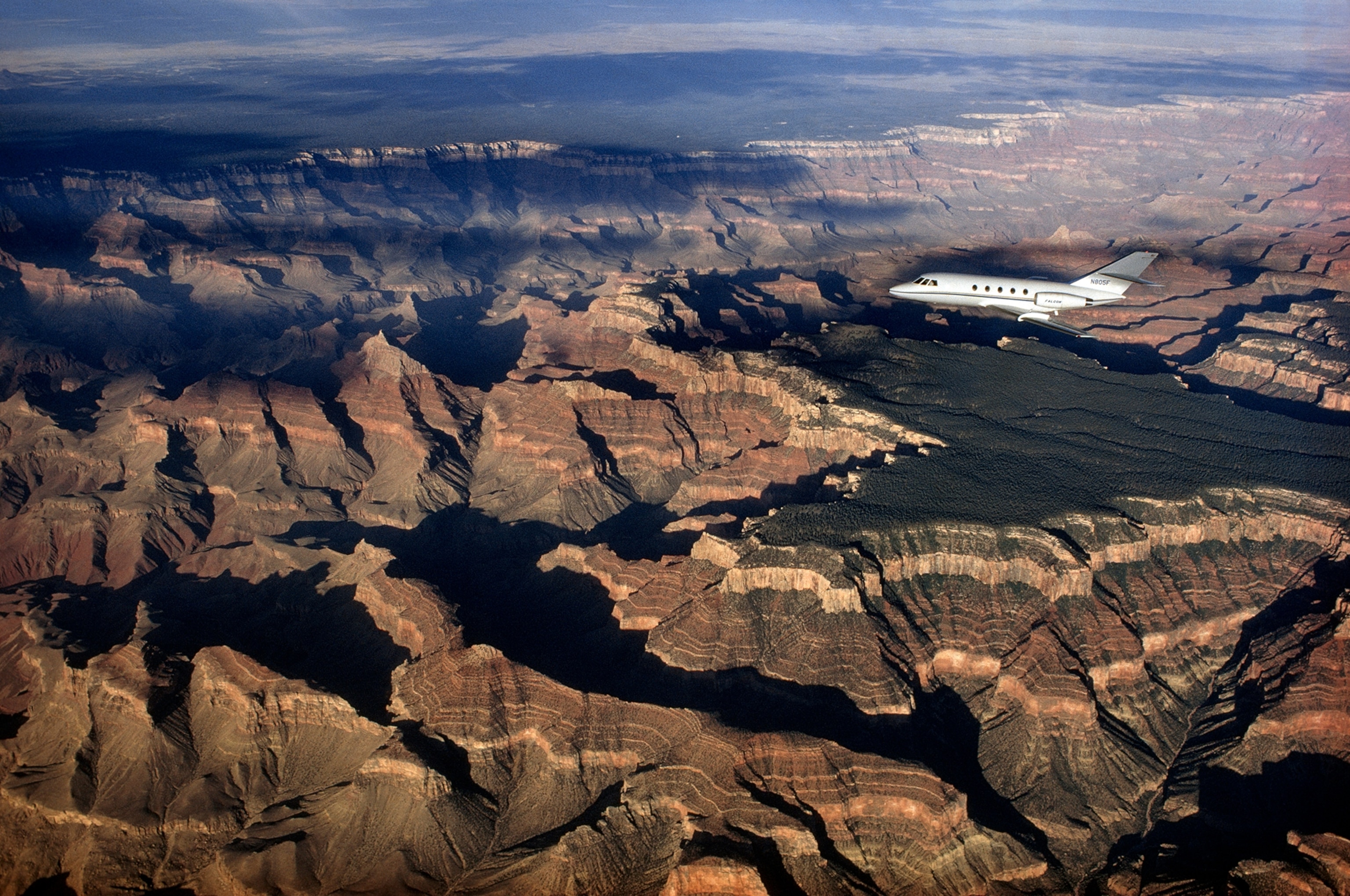 A Dassault fanjet Falcon aircraft flies over the Grand Canyon.