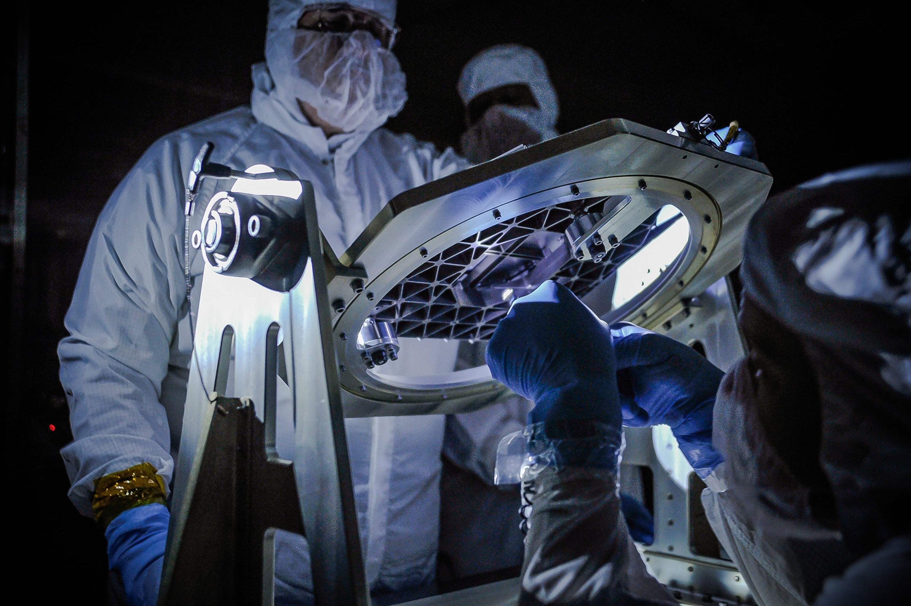 scientists examining a micro shutter array for the James Webb telescope
