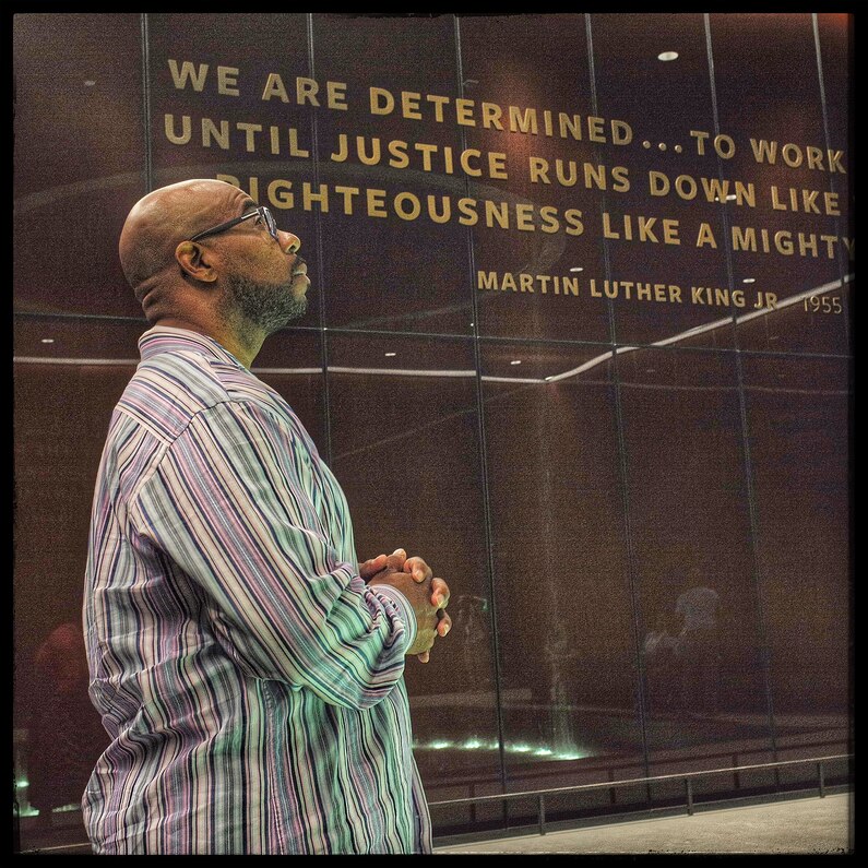 A man lifts his head to pray and acknowledge his moment of reaching to the top of the exhibition in the Contemplative Court of the museum. Here, the museumgoers are encouraged to sit and reflect in silence.