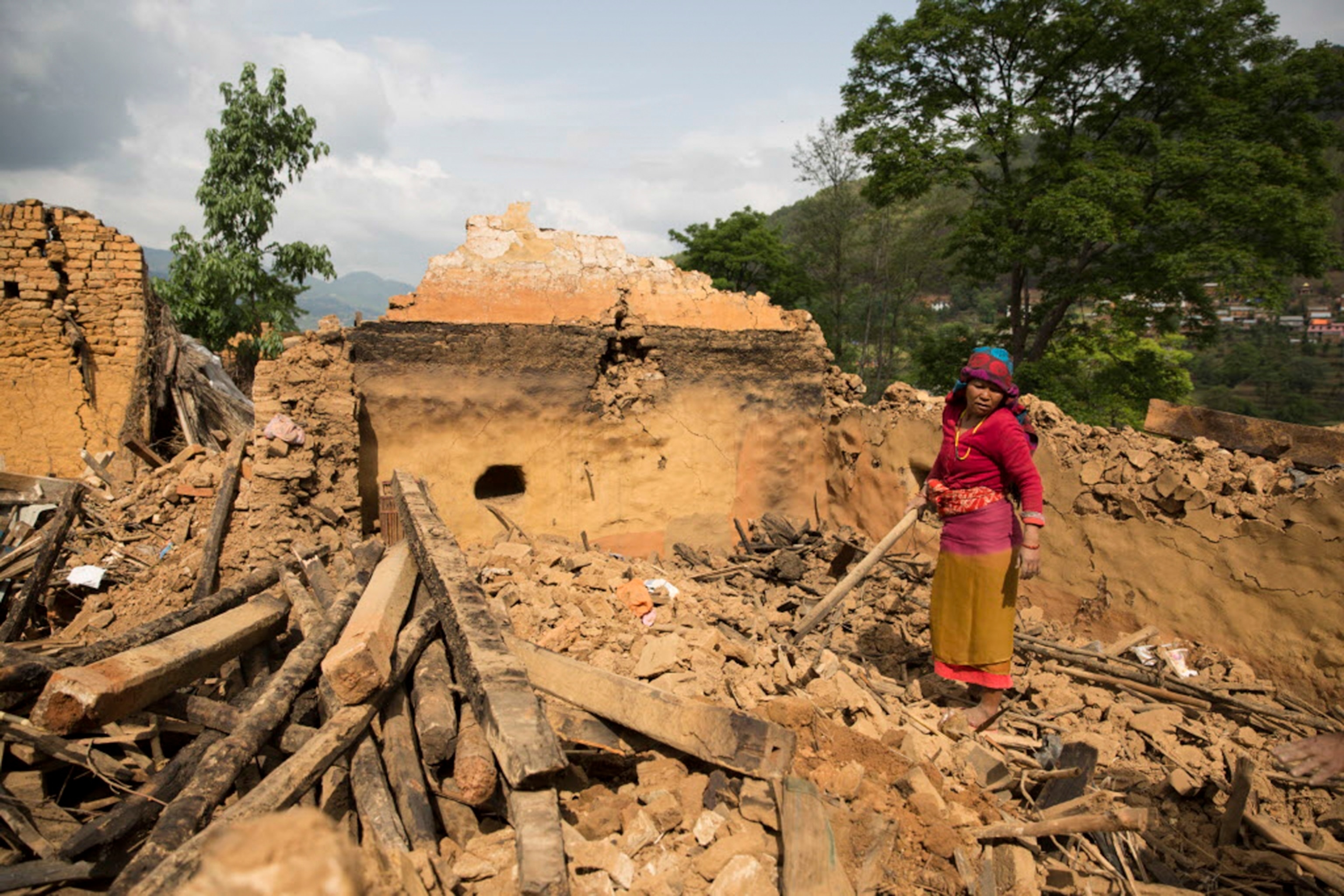 a Nepalese woman standing amongst the ruins of a structure