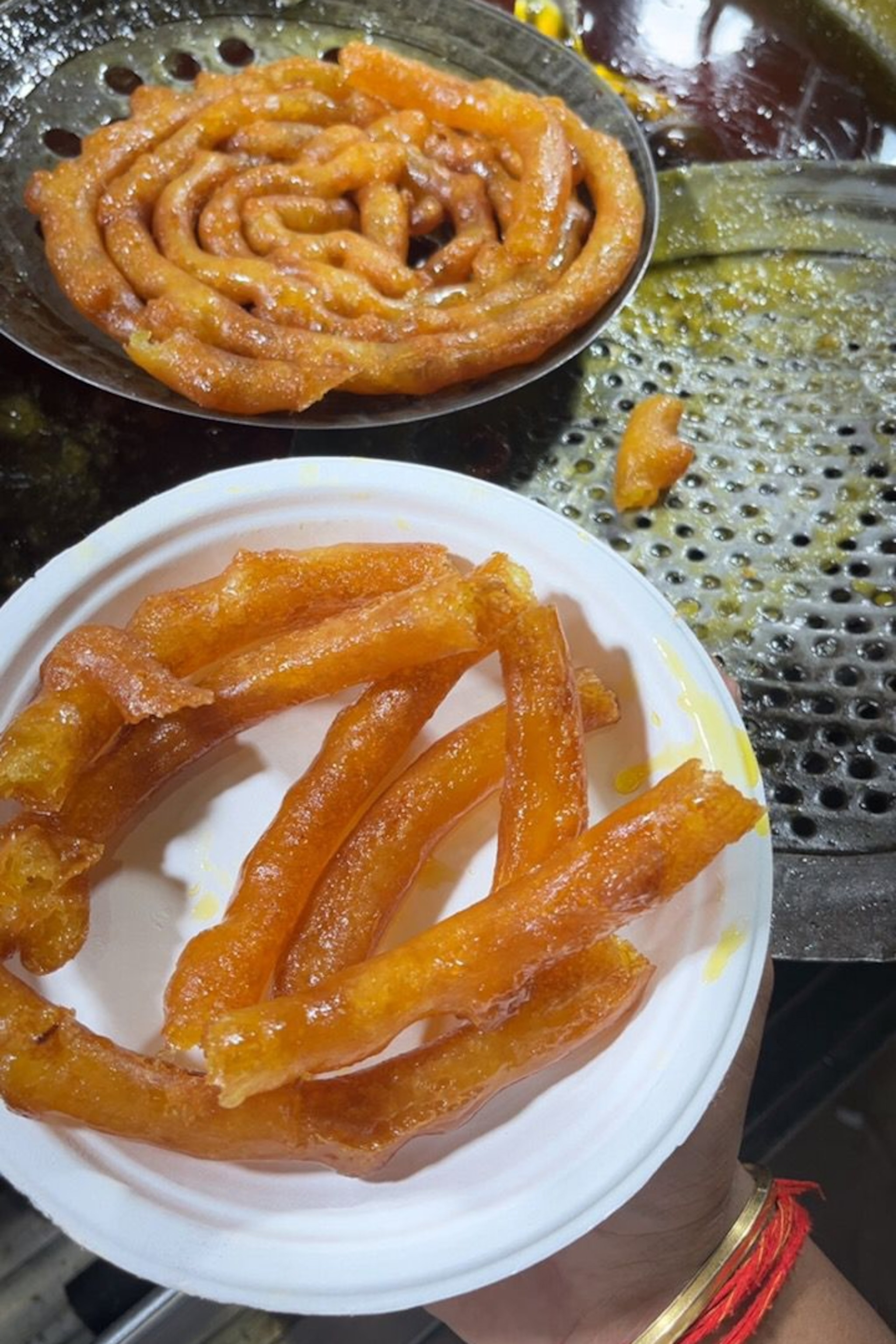 Fried tubes of batter soaked in syrup on a plate.