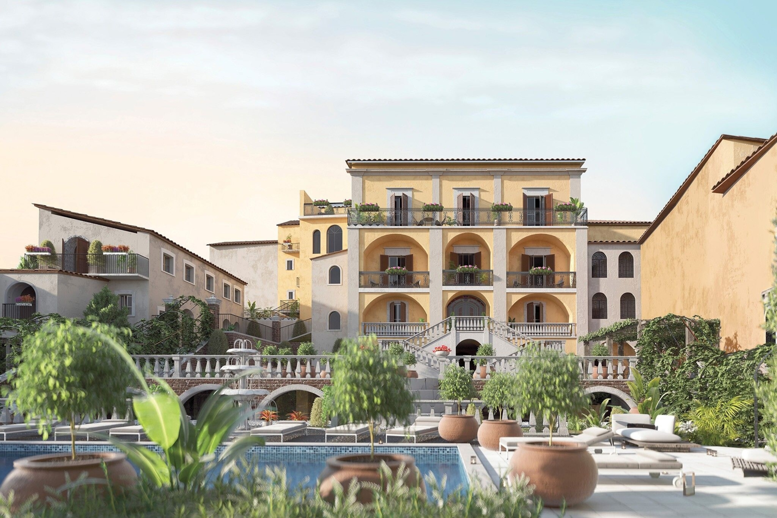 An Abruzzen palace. A swimming pool and sun beds in a white courtyard, below a large building.