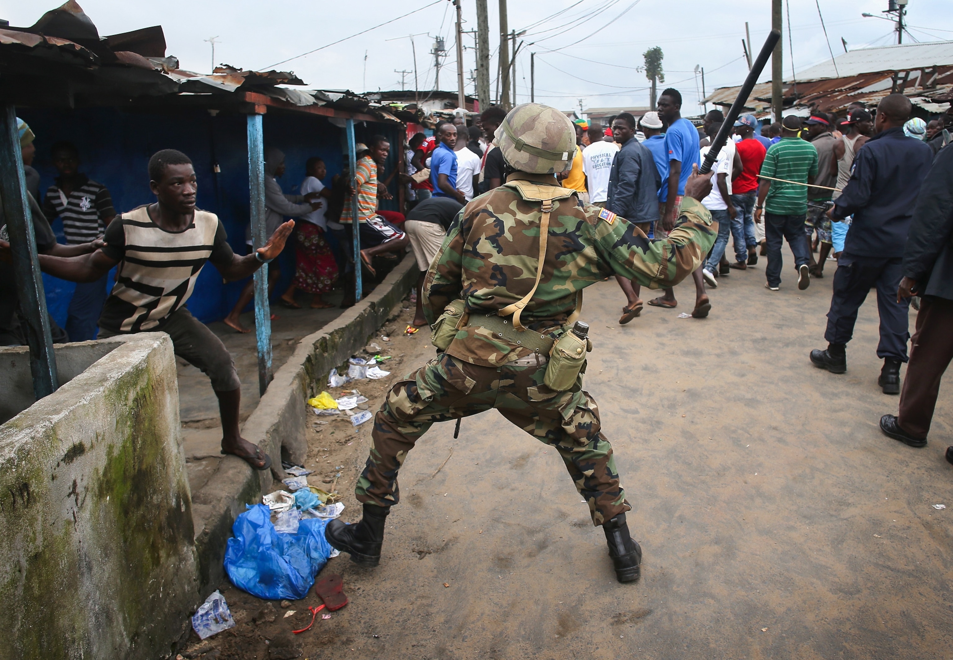 a Liberian health worker disinfecting a corpse after the man died.