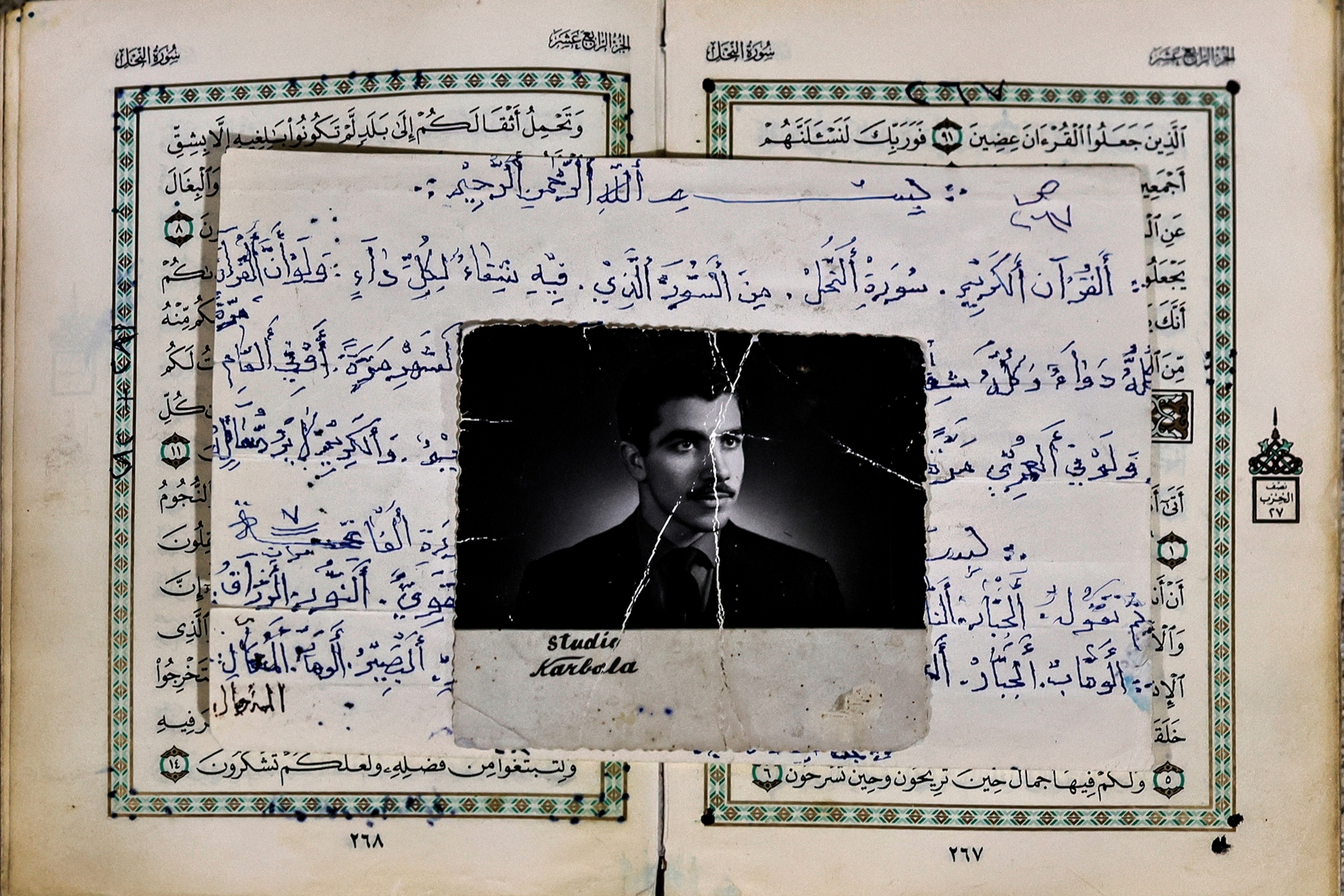 A black and white photo of a man lies on top of an open Quran
