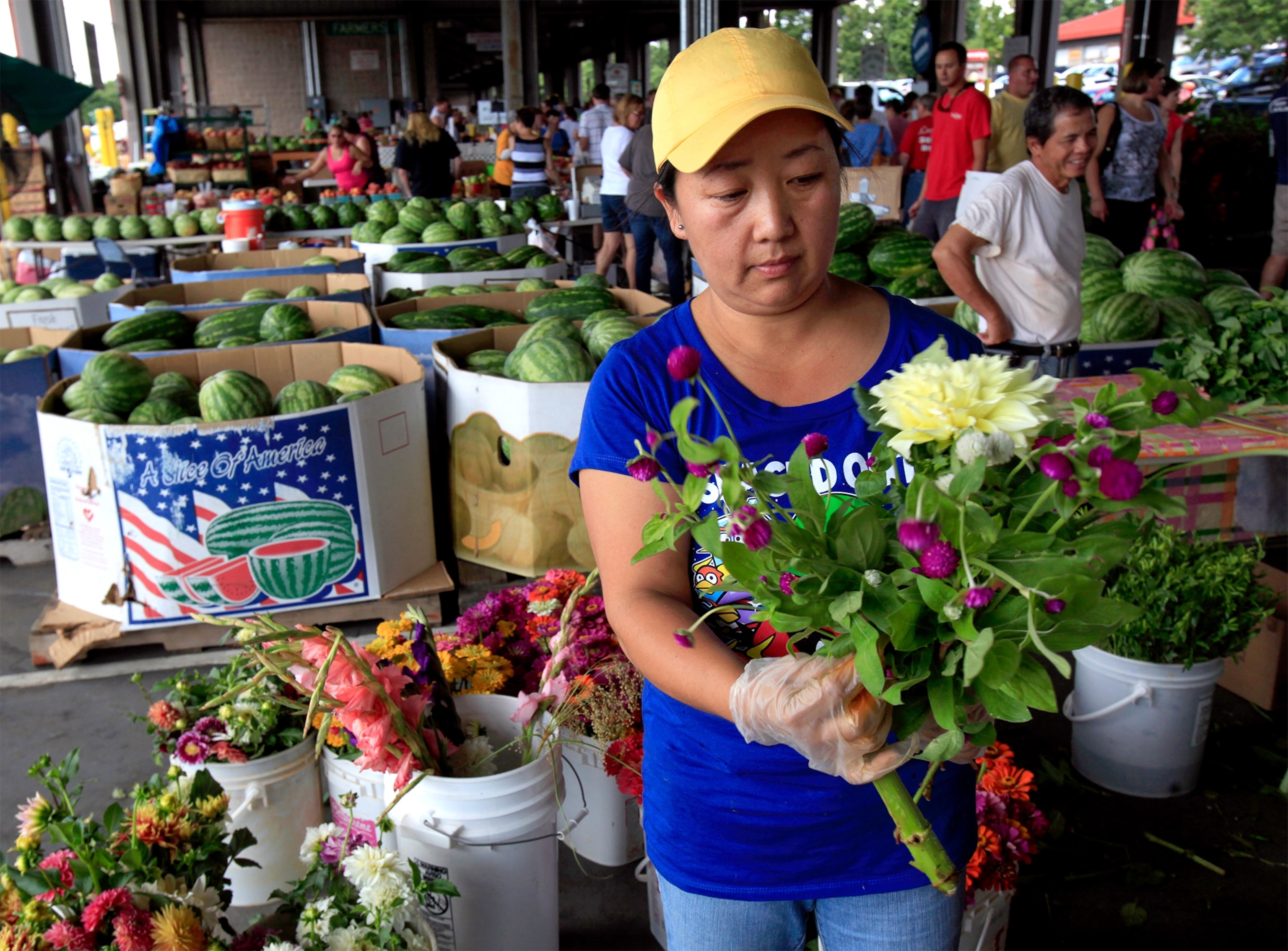 a woman making a bouquet of flowers at a farmer's market in North Carolina.