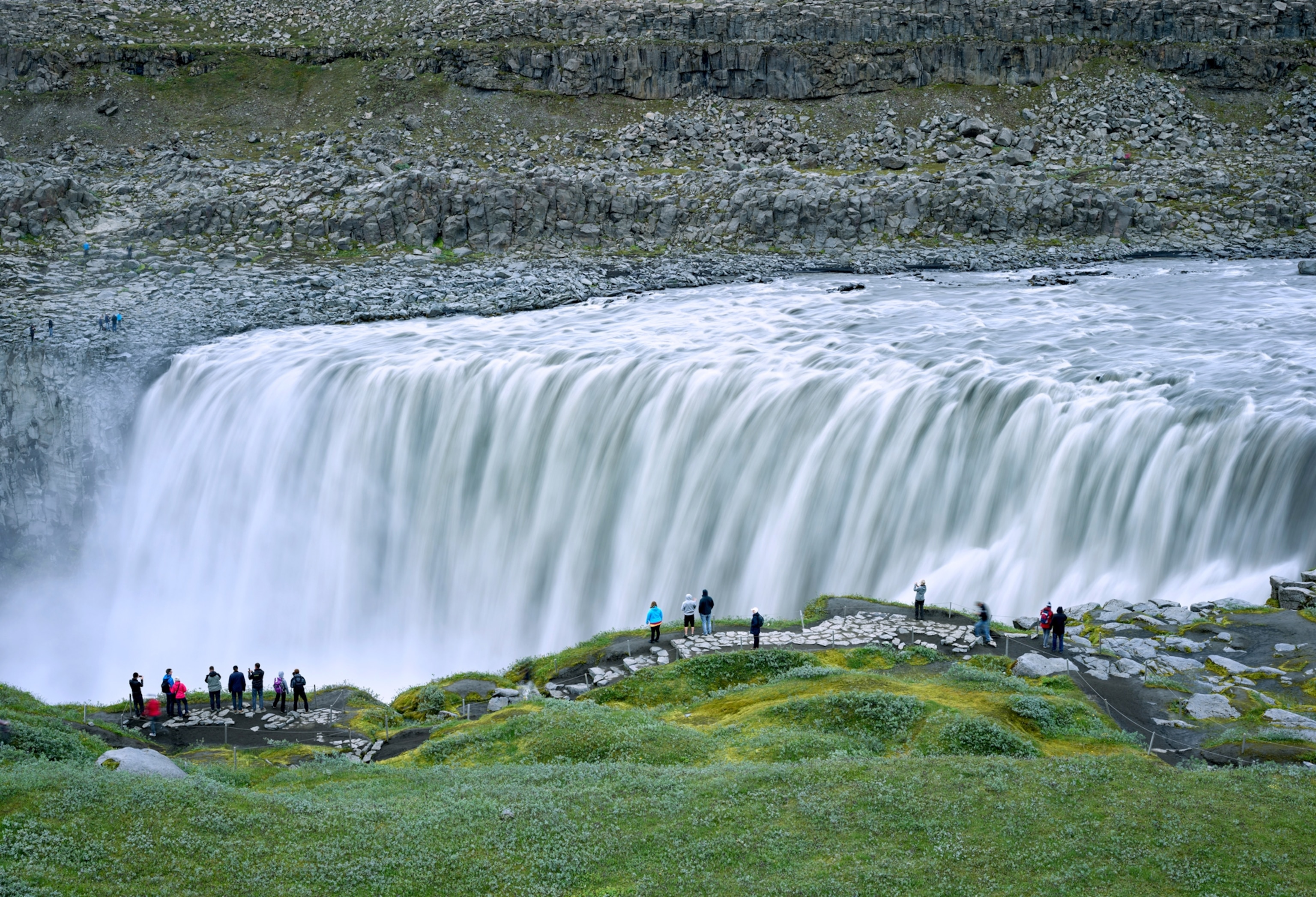 Tourists stand before the raging Dettifoss waterfall