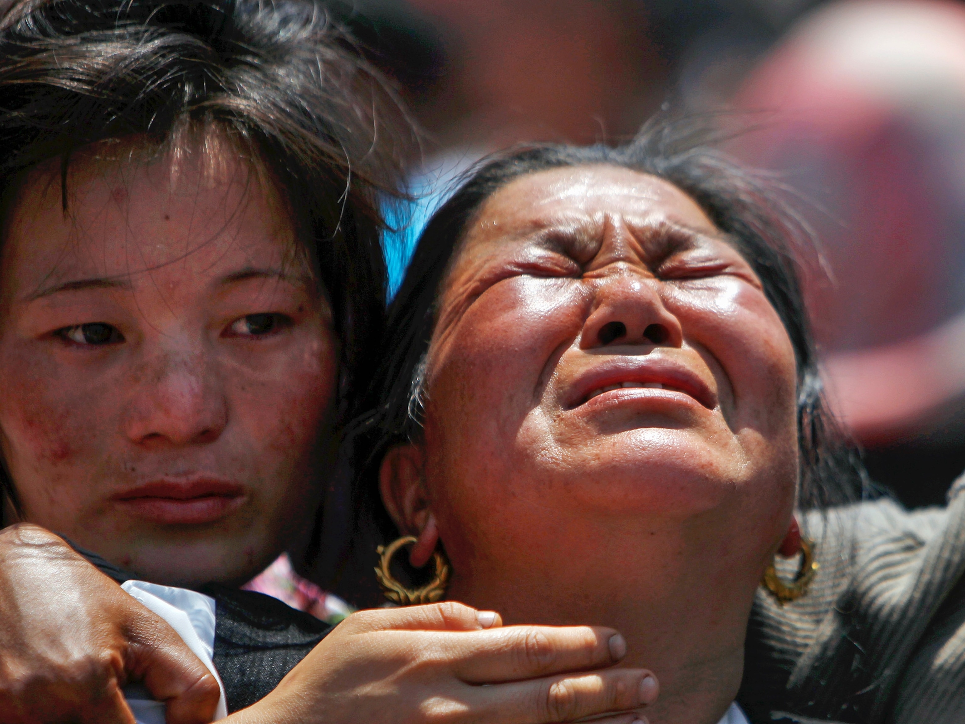 a monk setting fire to the body of a sherpa during a cremation ceremony.