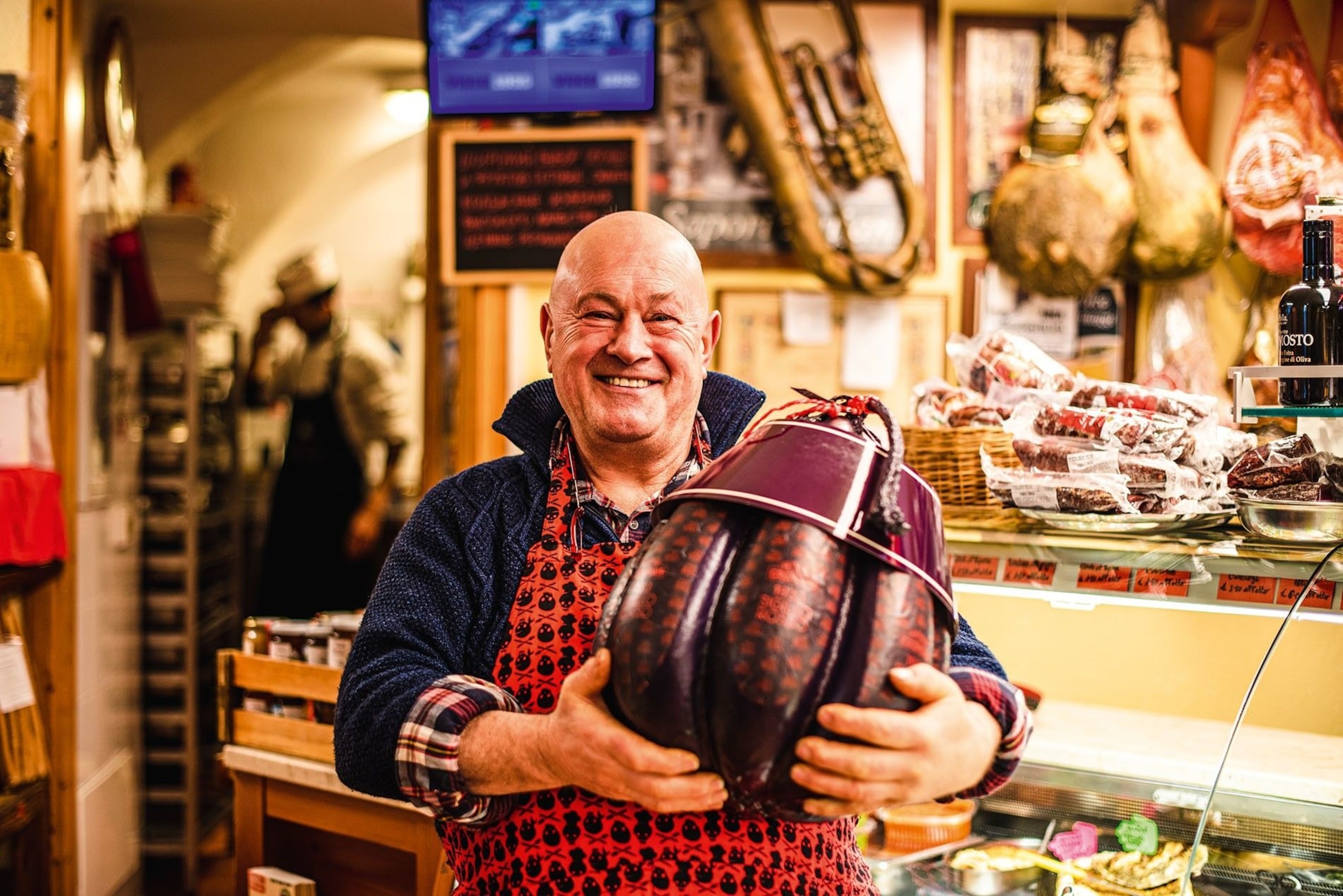 Santino Grosso, the owner of Ortofrutta Santino, holding provolone piccante Sigillo Rosso (Red Seal) cheese.