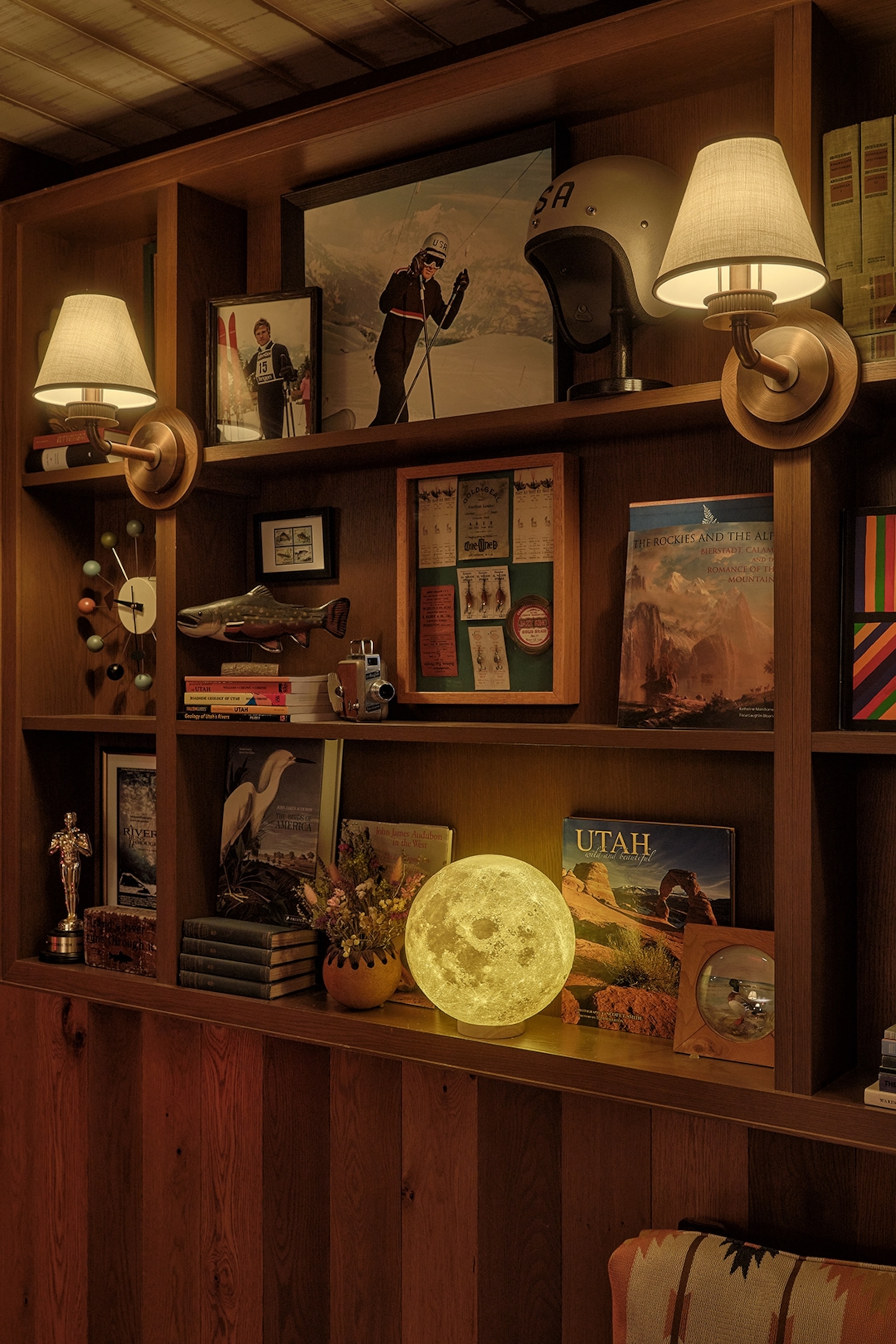 A close-up of a book shelf, decorated with images of actor Robert Redford and a moon-shaped lamp.