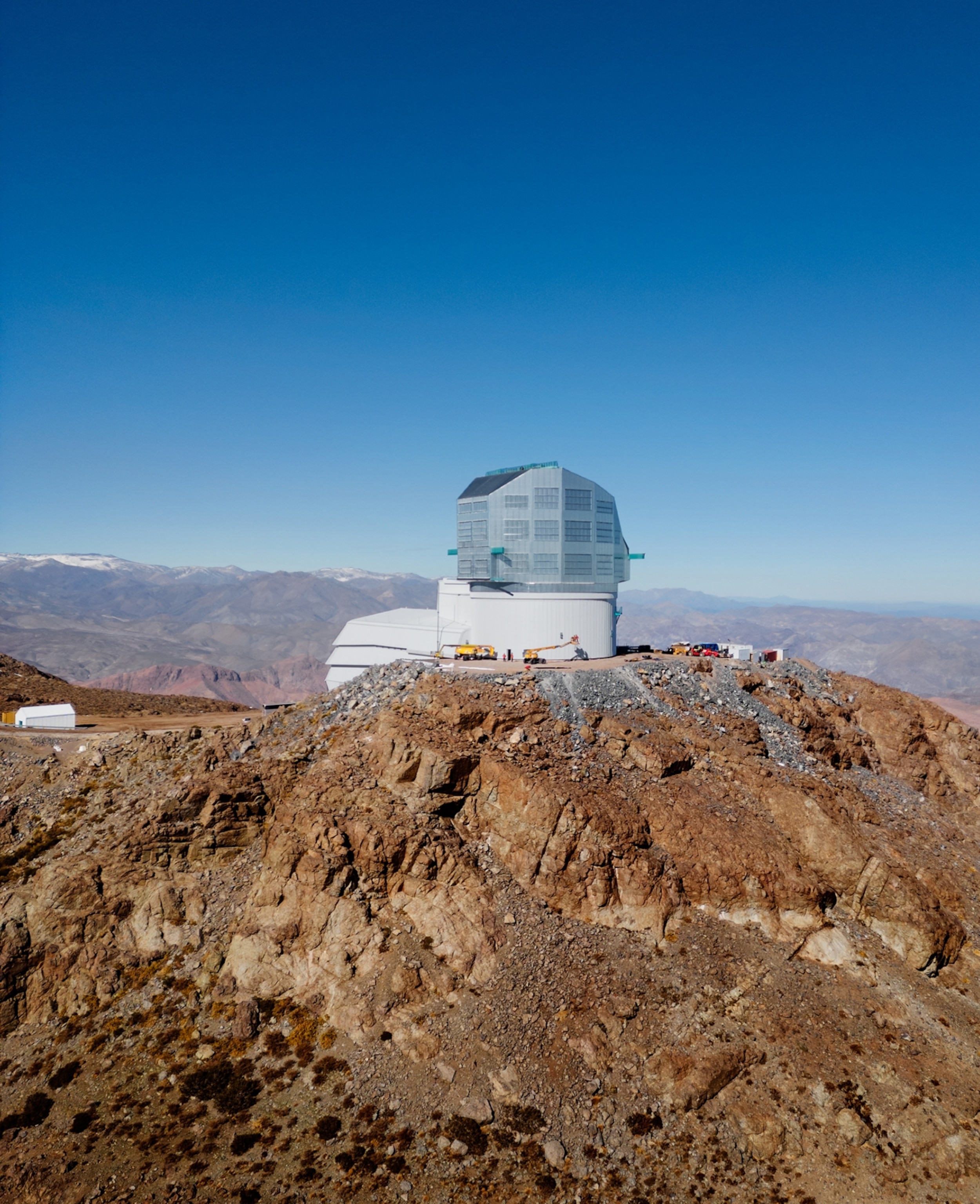 NASA Space Technology The Vera C. Rubin, an observatory with a dome appearance, is seen amongst the brown mountains of Chile.