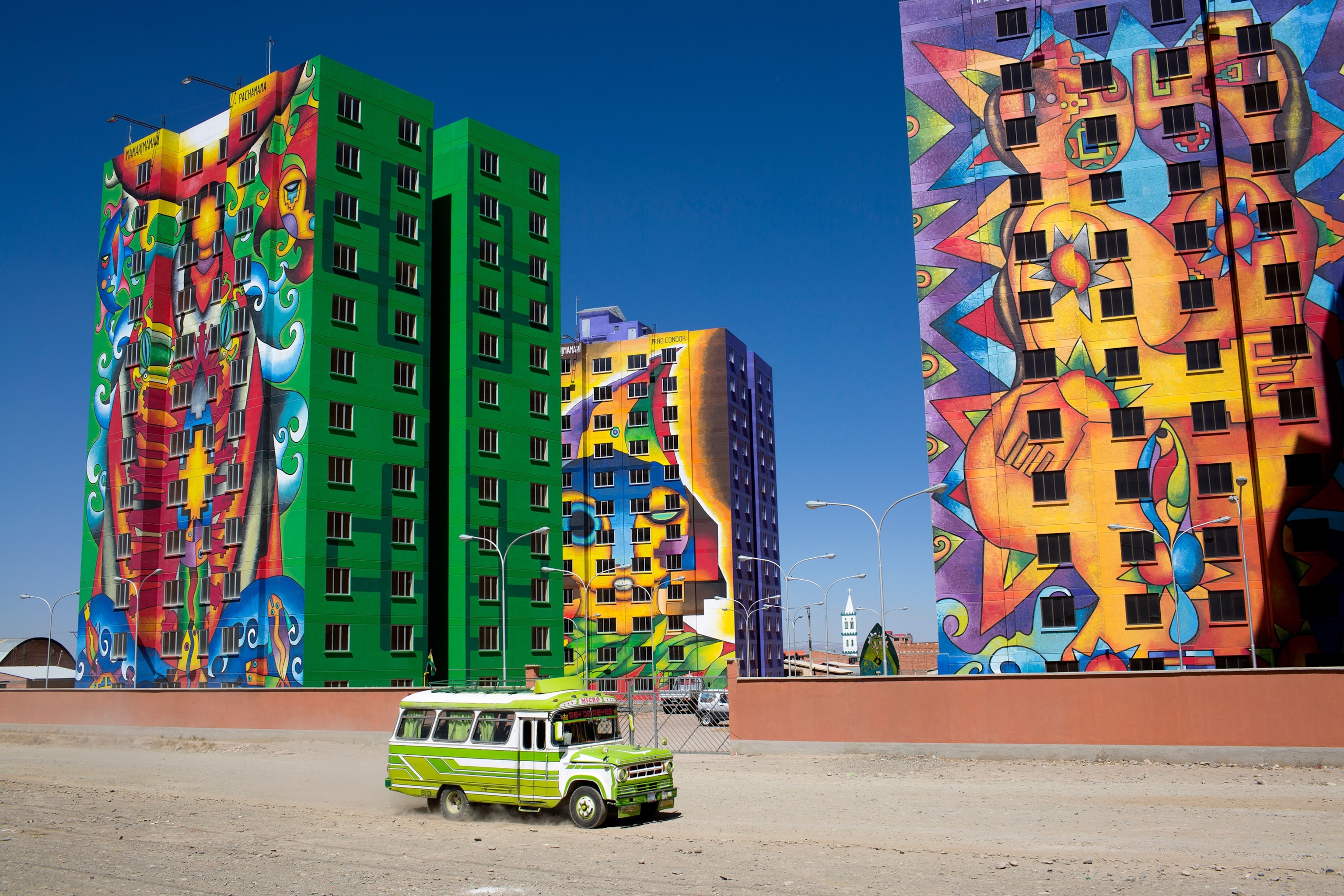 a bus driving past colorful buildings in El Alto, Bolivia