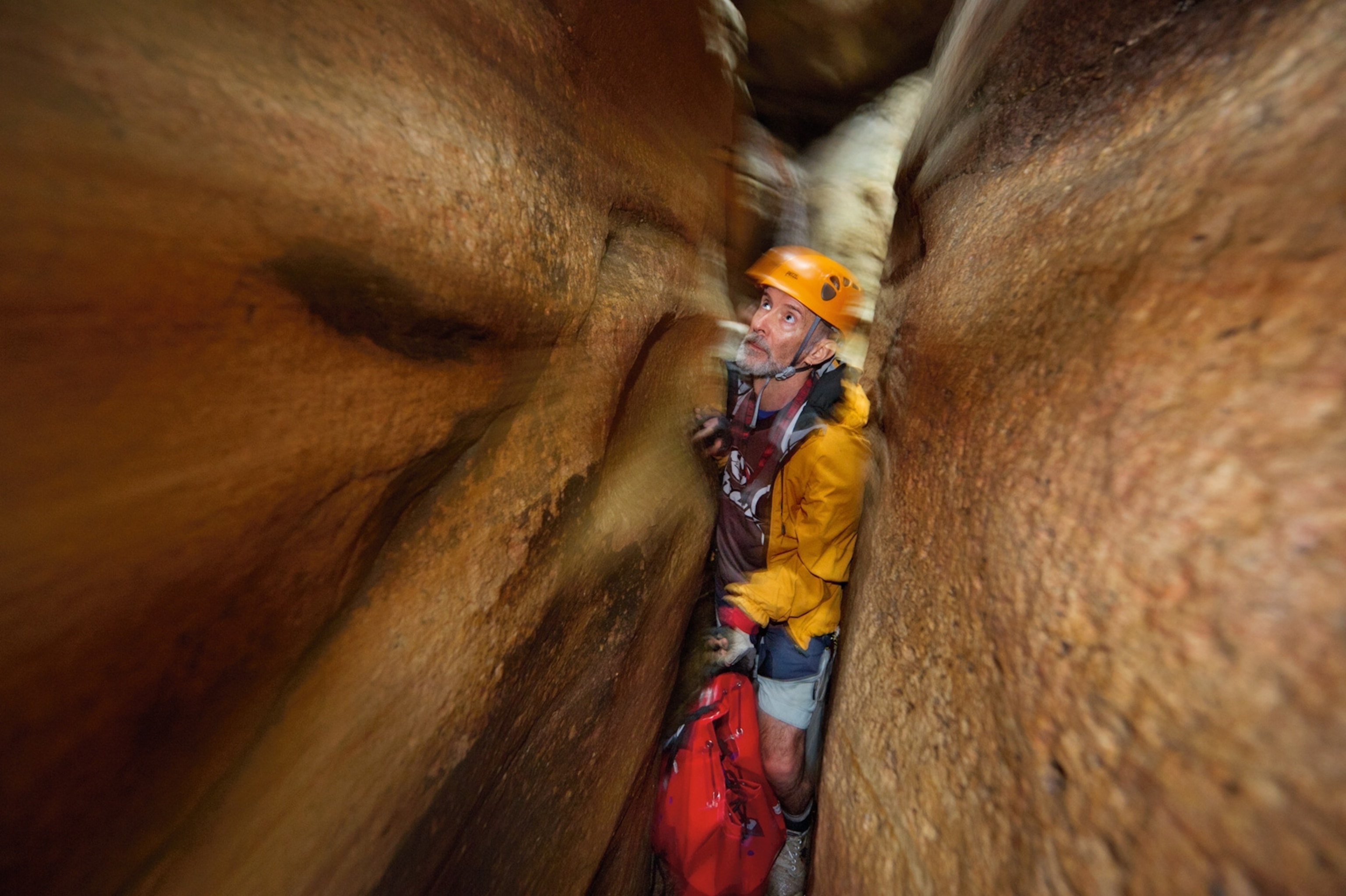 a canyoneer squeezing through Tiger Snake Canyon