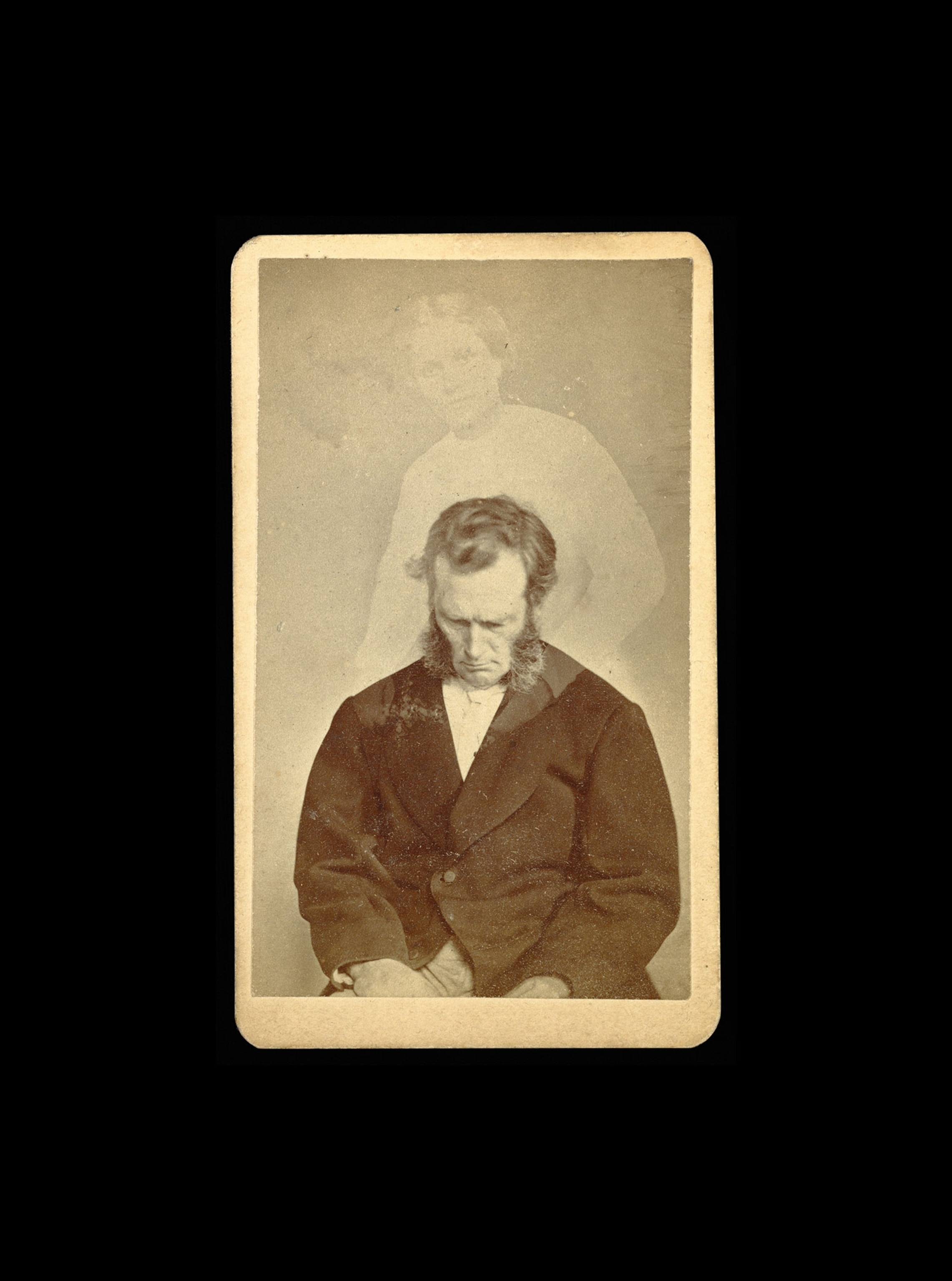 Portrait of a man with full sideburns looking down. A faint image of a woman is visible above him.