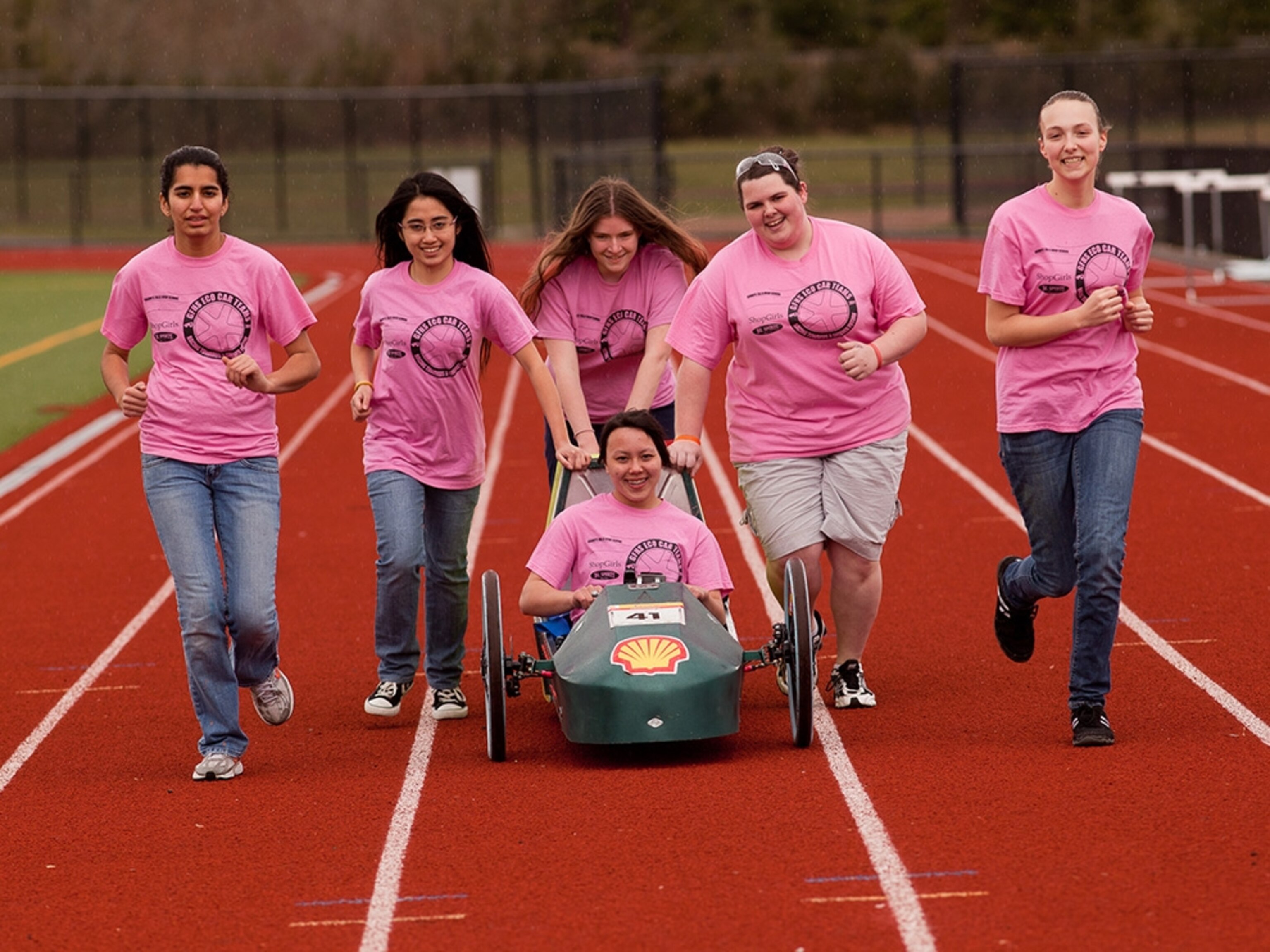 All six members of the ShopGirls team take a lap with the Iron Maiden around the school track