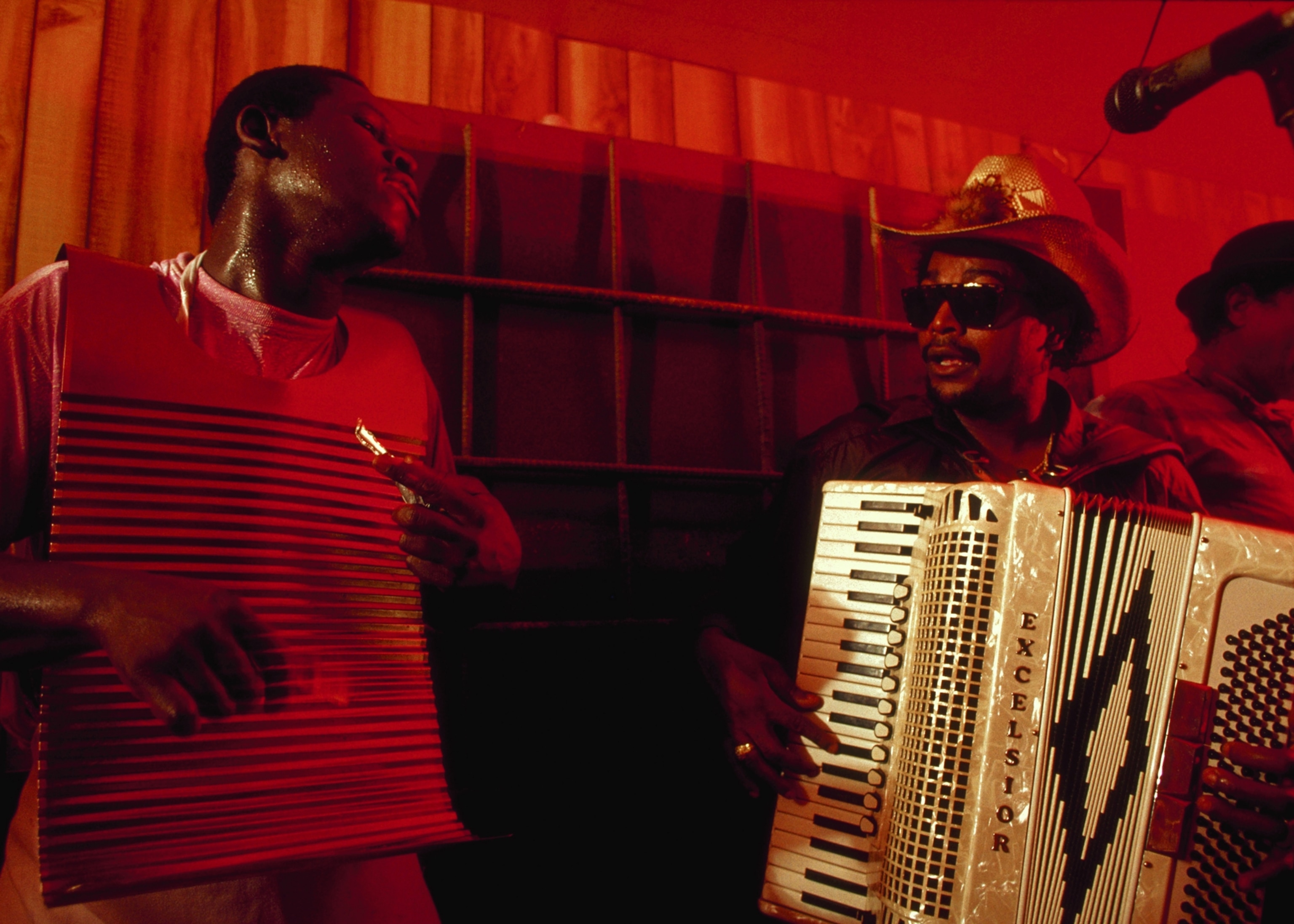 As a member of his band strums on a zydeco frottoir, a metal washboard-like instrument, Nathan Williams plays the accordion during a performance at the Dauphine Club. Parks, Louisiana, USA. | Location: Dauphine Club, Parks, Louisiana, USA.