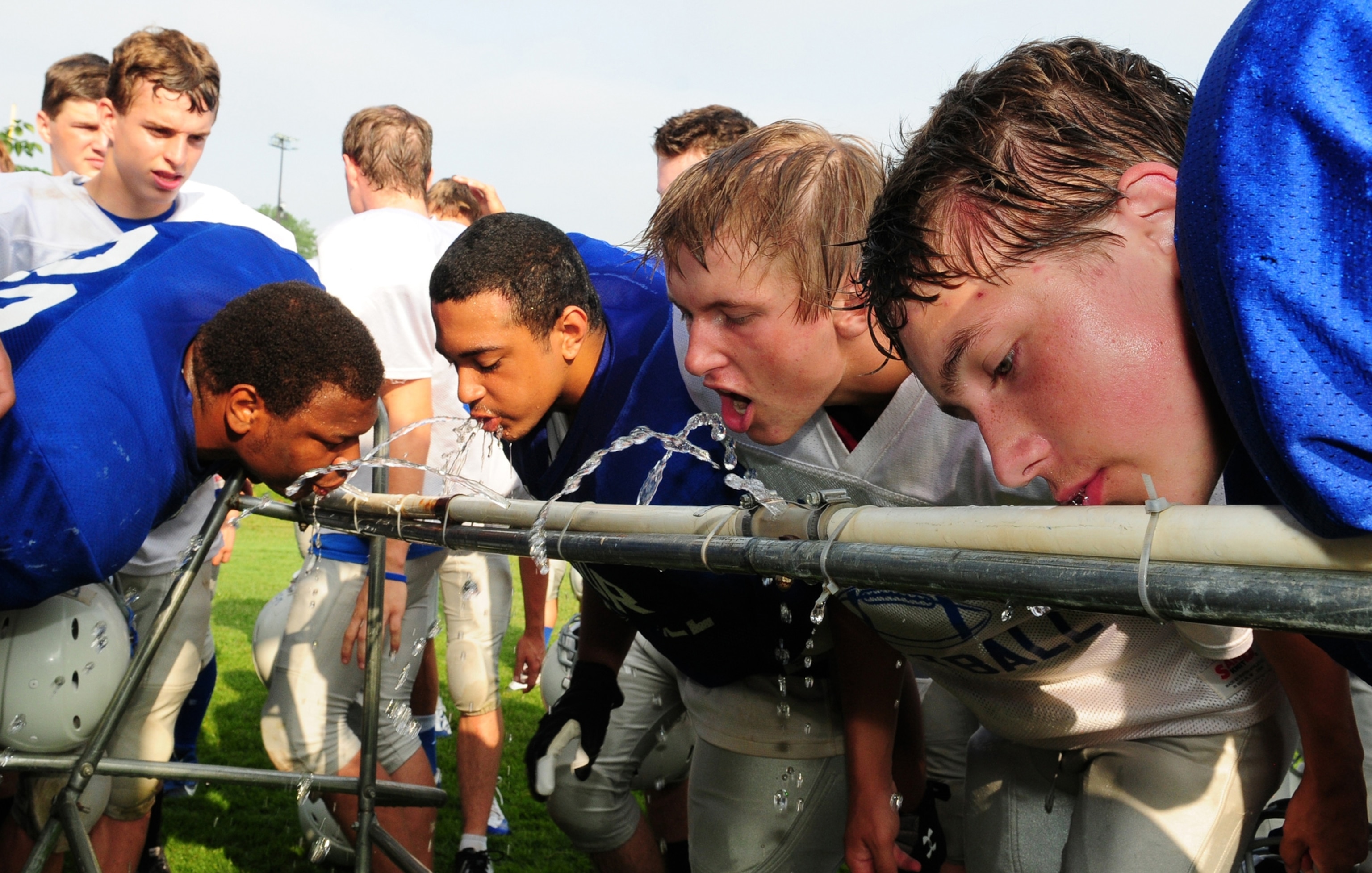 High school football players drink water in Brainerd, Minnesota.