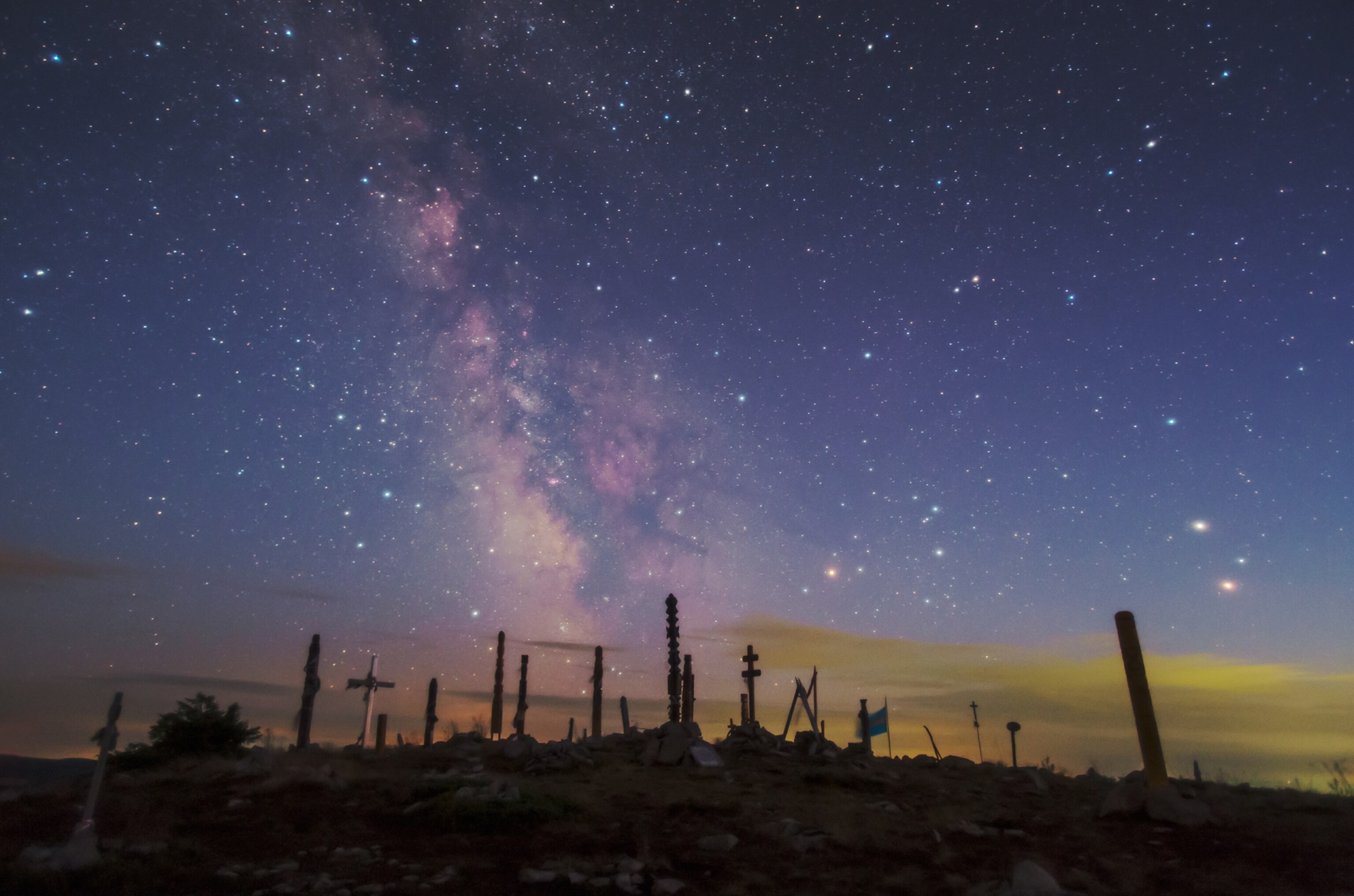 The Milky Way in the constellation Scorpius and Sagittarius (towards the galactic center) appear at dusk over the peak of Madarasi Hargita (1801m), a sacred site for szekely culture, in Romania. Planets Mars and Saturn are on the right in a celestial conjunction.