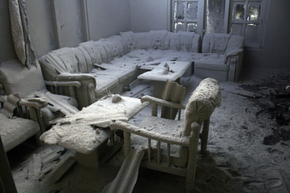 Ash from the Indonesian Mount Merapi volcano eruption covers furniture inside a house.