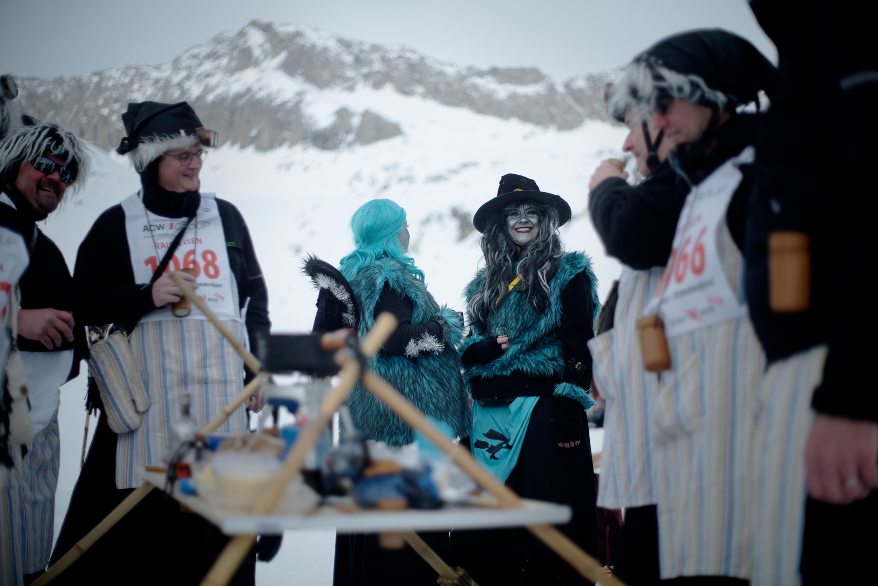 Skiers dressed as witches melt cheese for a fondue picnic during Belalp Hexen festival in Belalp, Switzerland. Participants stop along the slopes during the event to eat and drink. This team made there own portable table that uses broomsticks as legs.