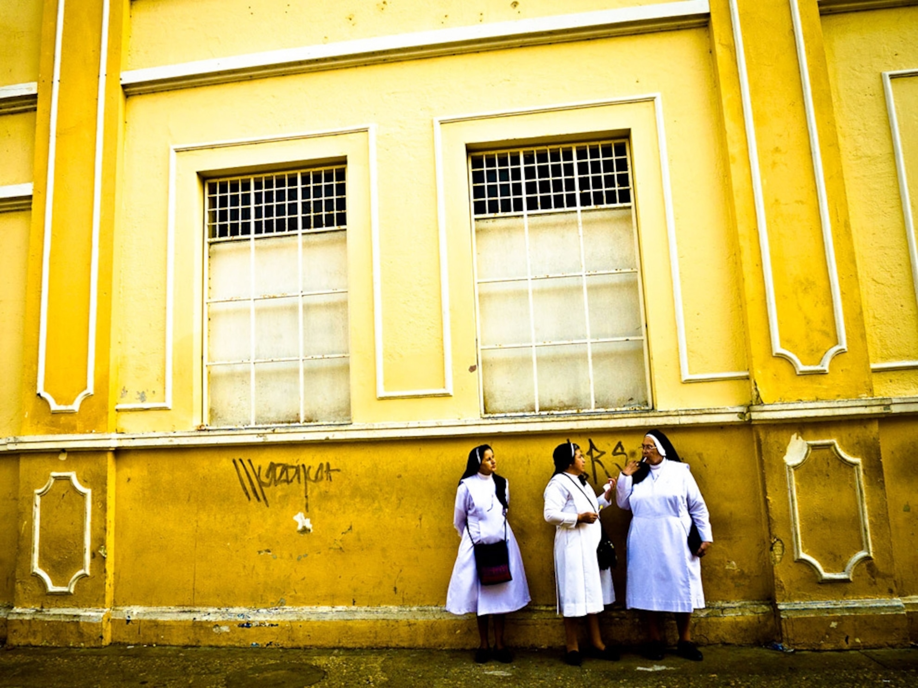 Nuns eating lollipops outside a parochial school