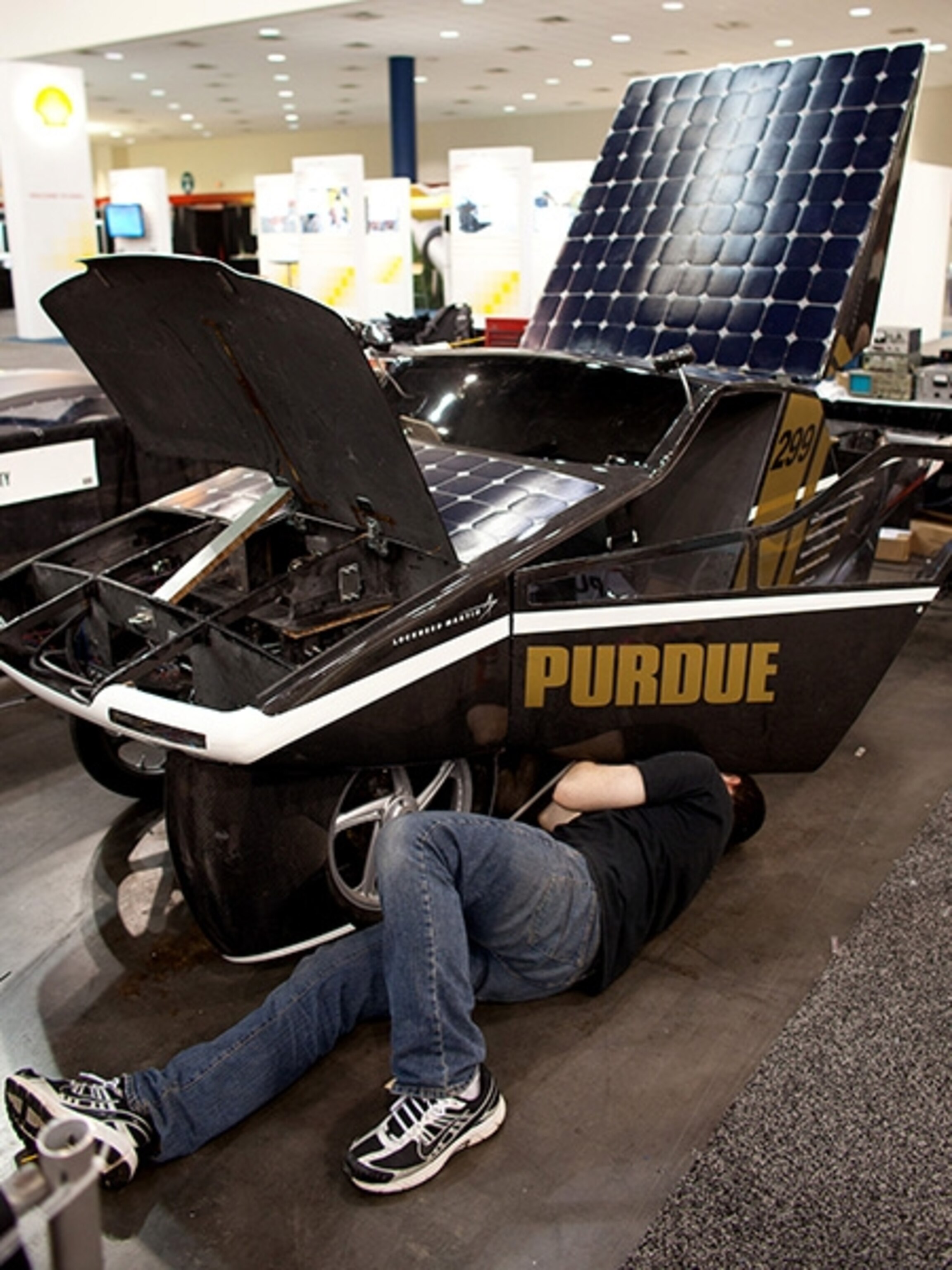 A team member works under the Purdue University solar powered Urban Concept division car. The Purdue entry is designed to be a street legal car.