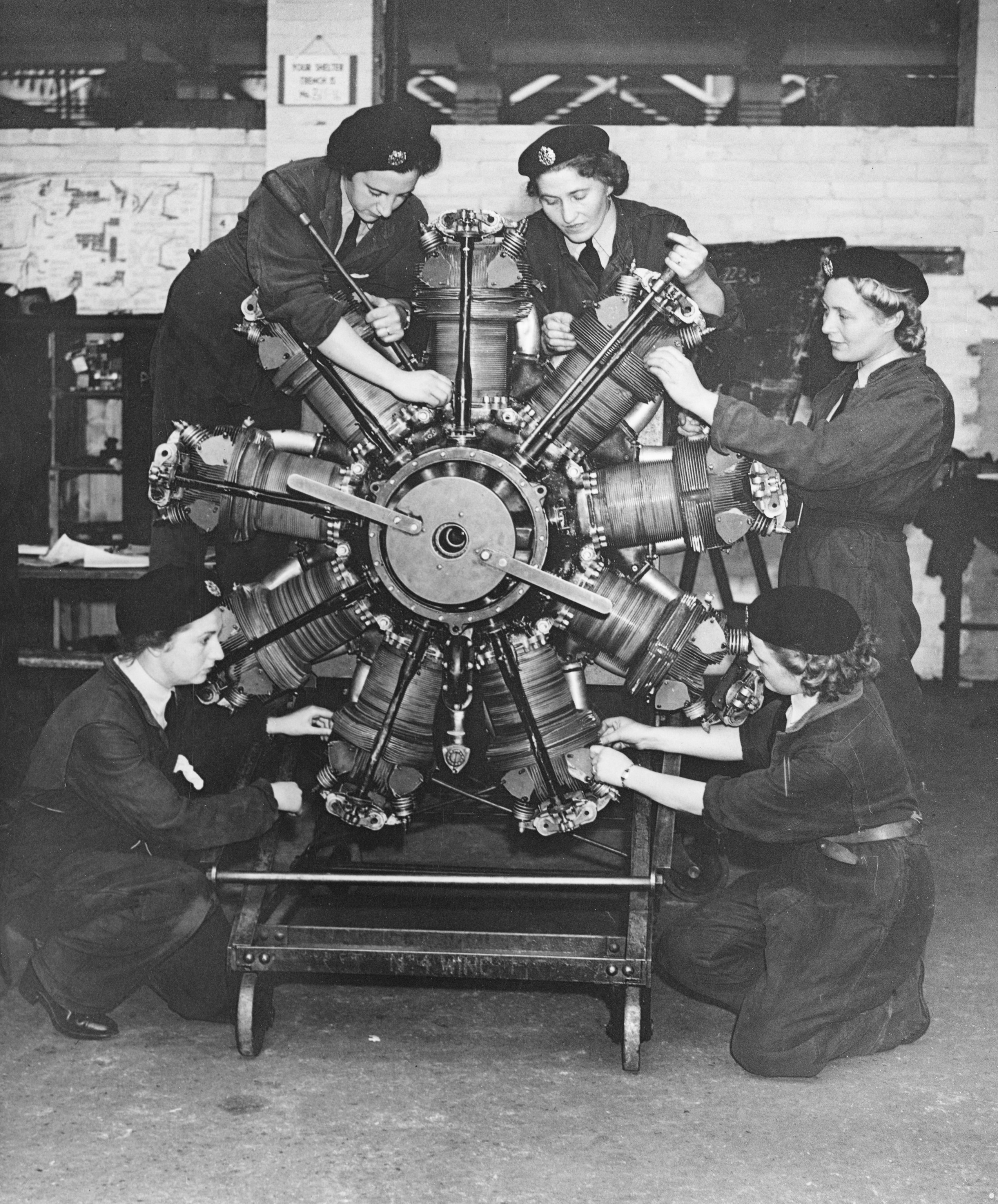 Flight mechanics of the Women's Auxiliary Air Force (WAAF) undergo maintenance work on an aircraft radial engine at Technical Training Command.