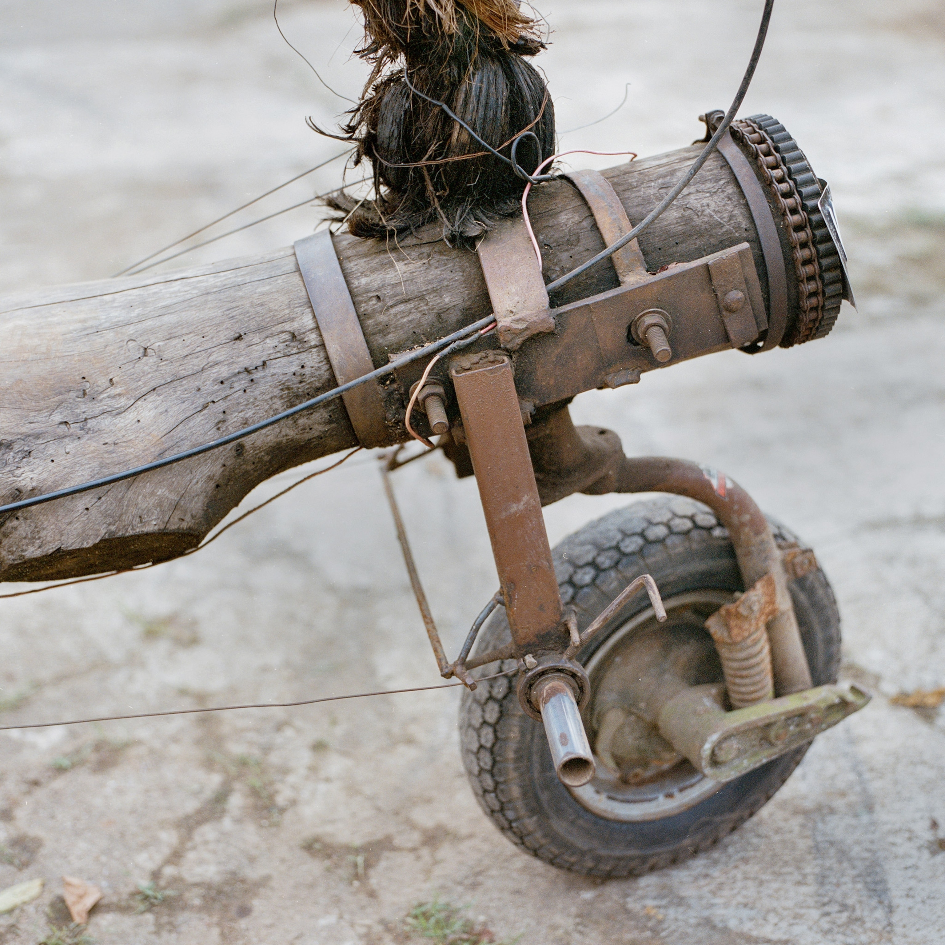a wheel fashioned to a log on an extreme vespa in Indonesia