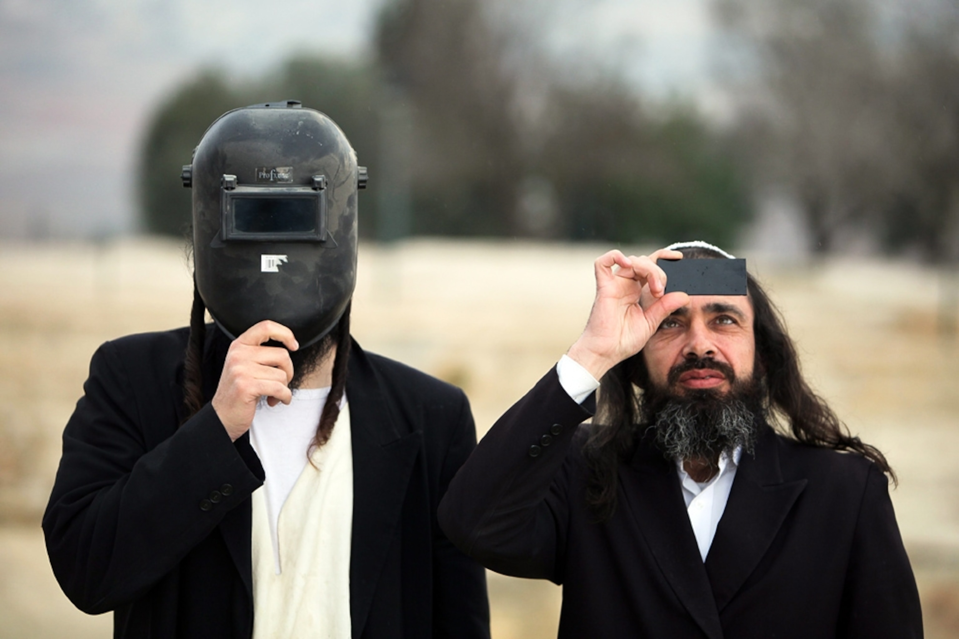 Two Israeli men using protective gear to watch a solar eclipse (picture).