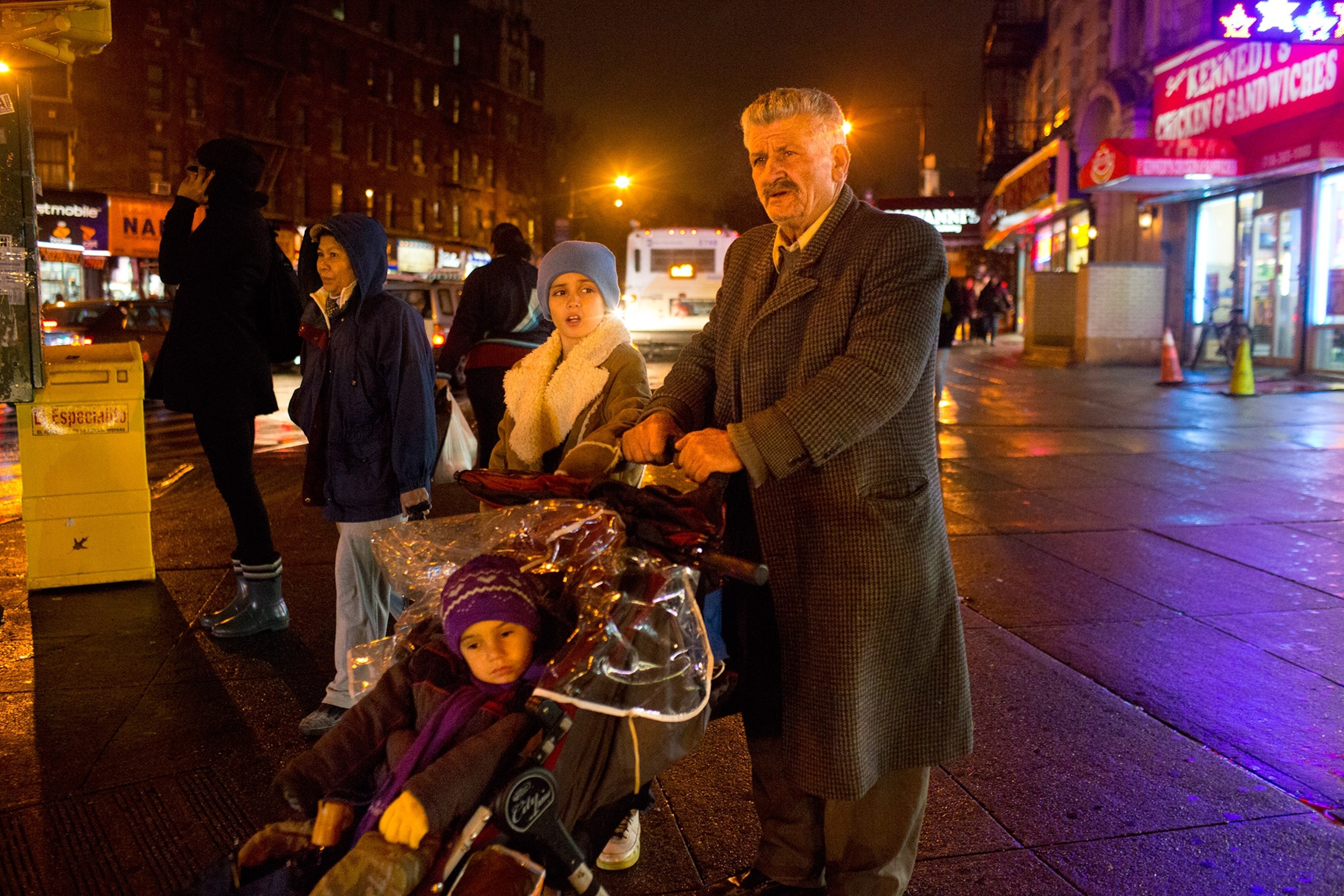 George Christou with his children outside while it is dark outside in New York City, waiting to get food from one of the services that provides free food