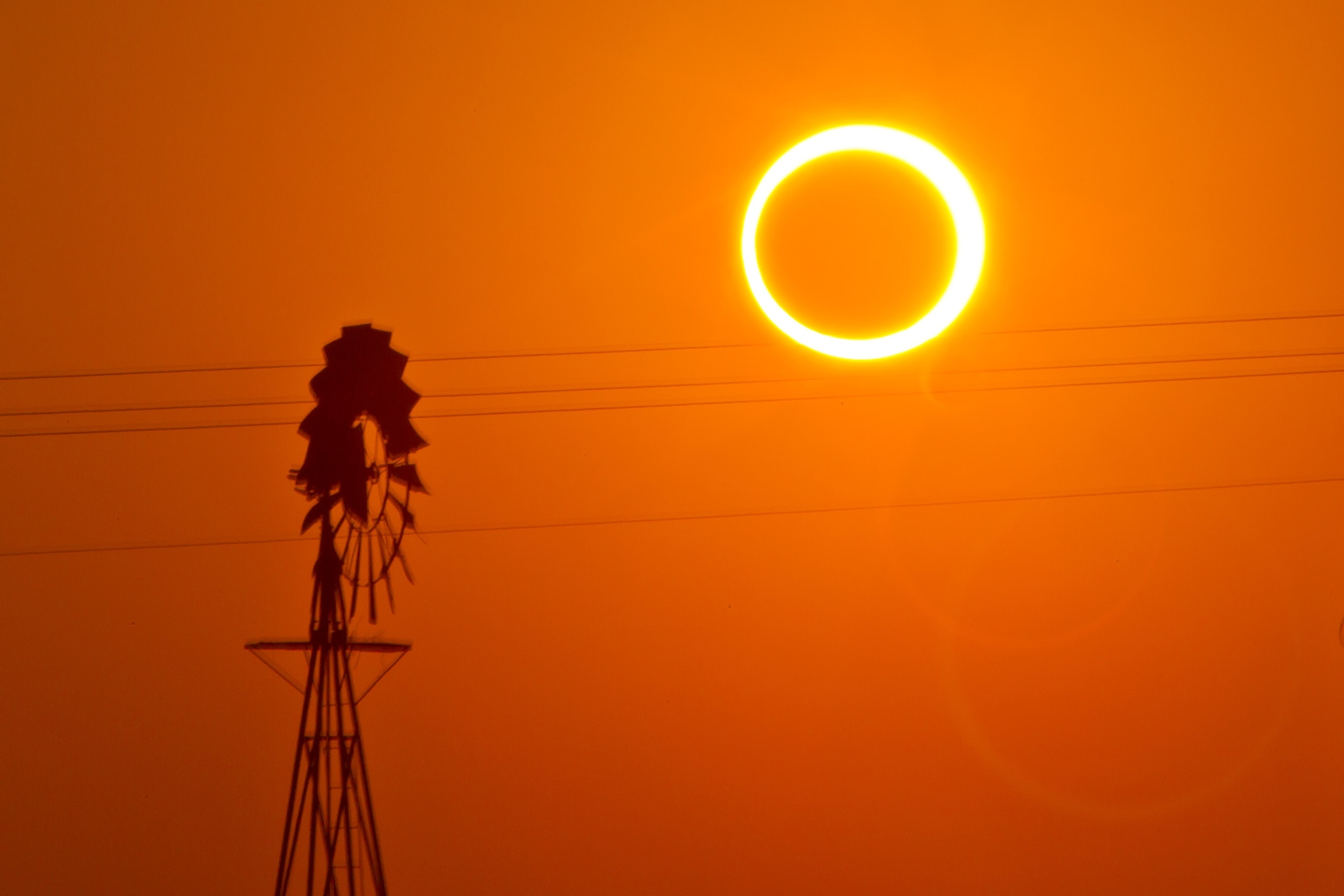 a solar eclipse by a windmill
