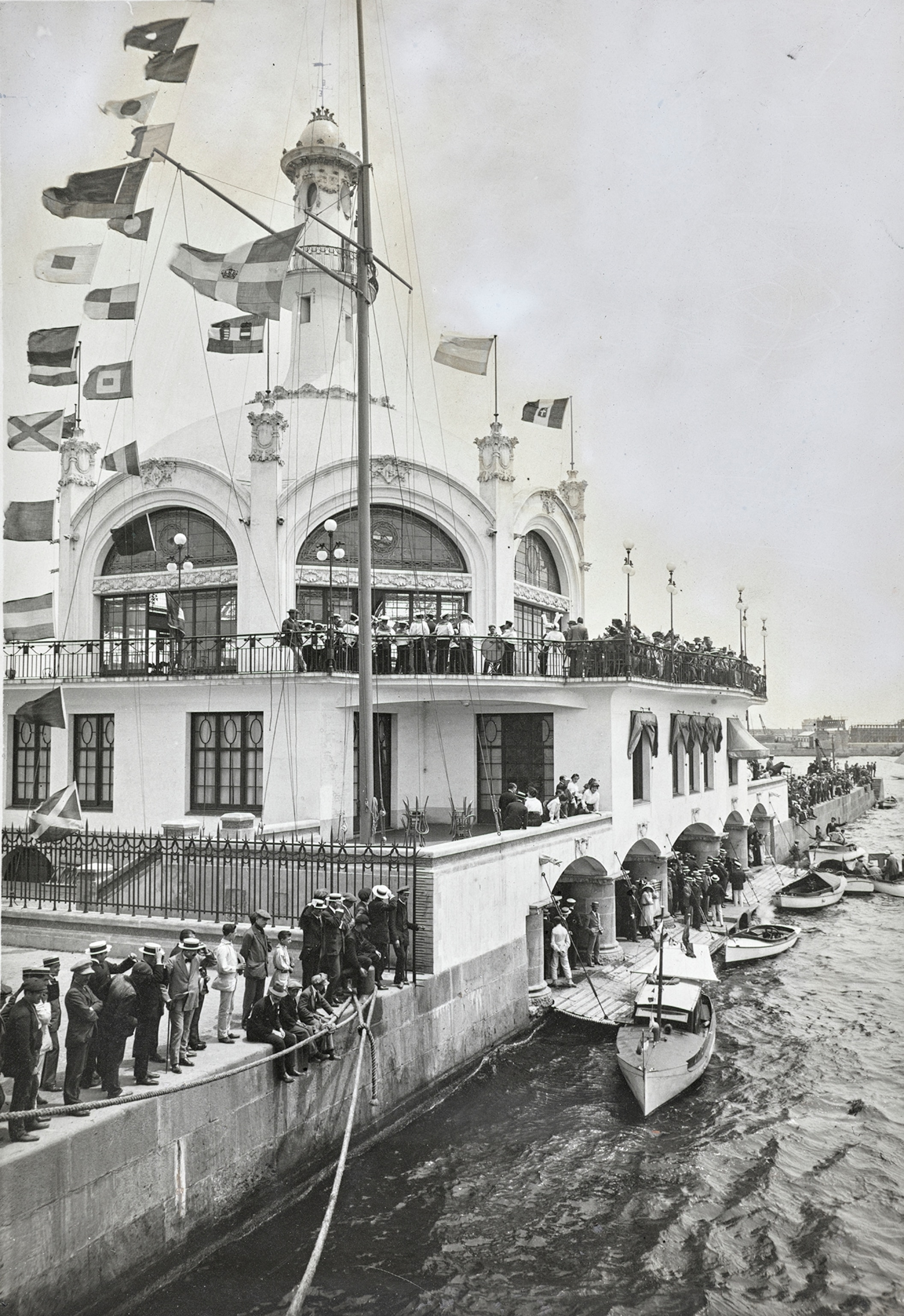 People stand along the edges and balconies of the Regatta Club.