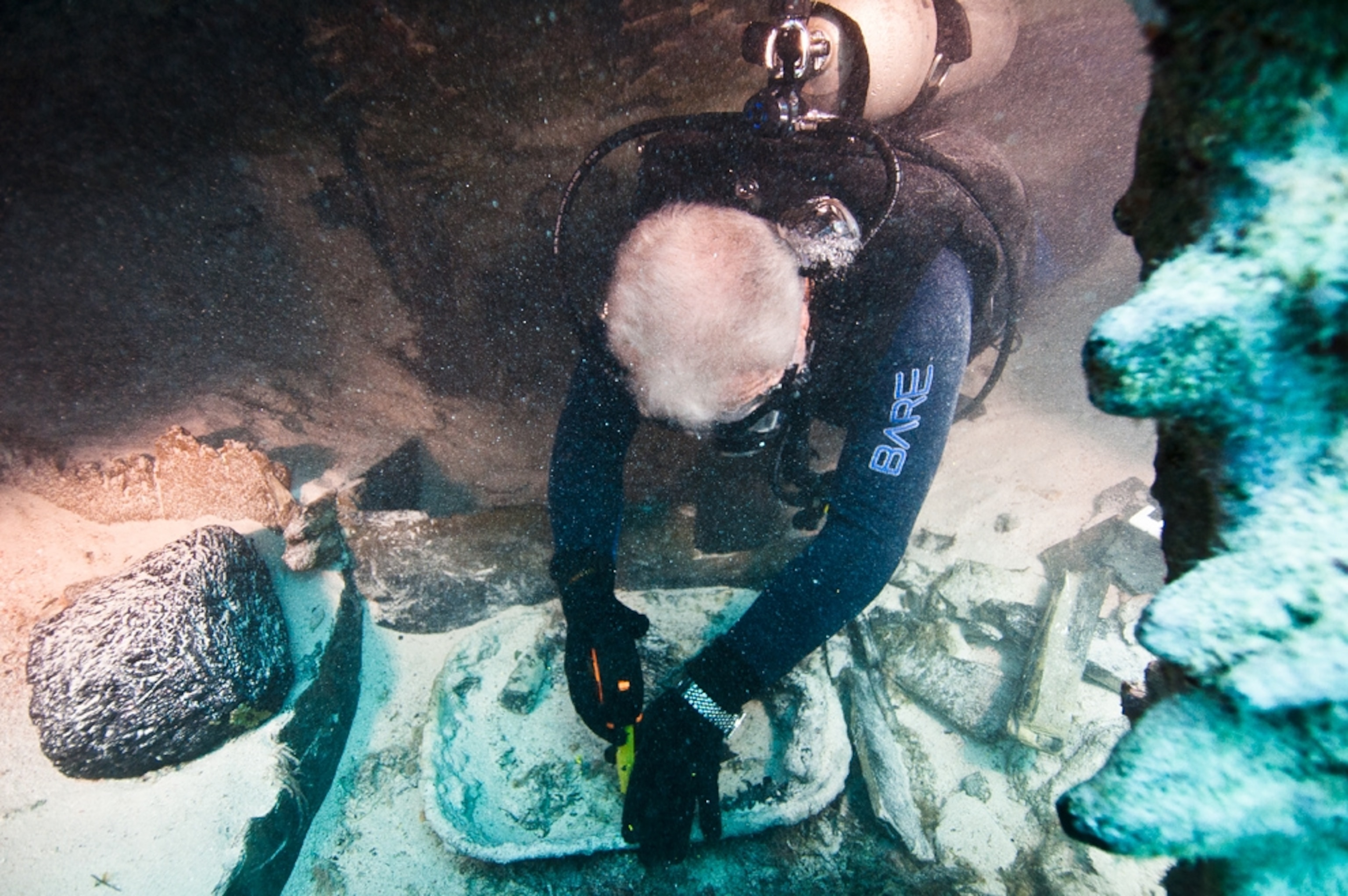 Shipwreck picture: an archaeologist measuring a tin basin found near the Civil War-era Mary Celestia off Bermuda