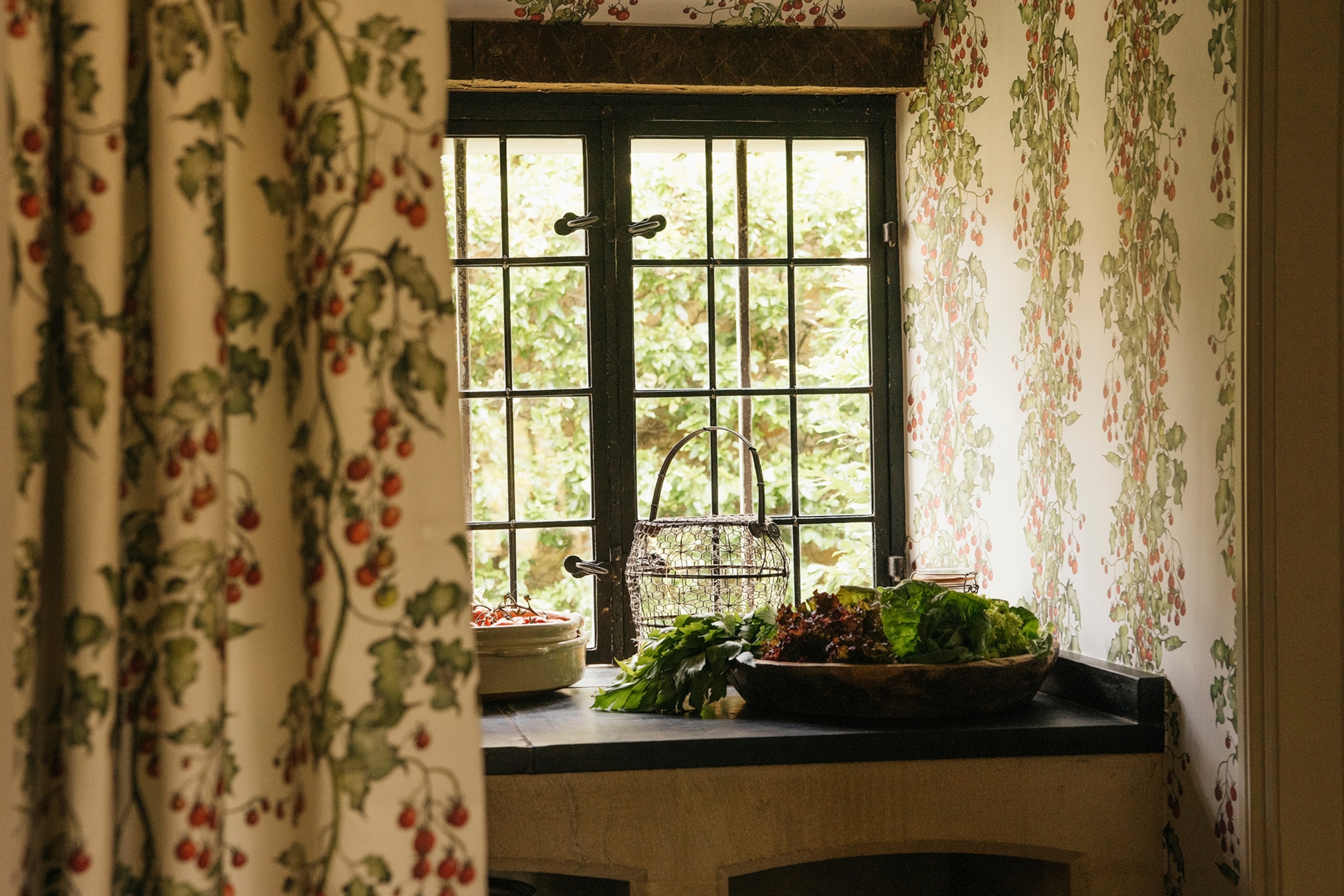 A cosy farmhouse window from the inside, framed by heavy curtains.