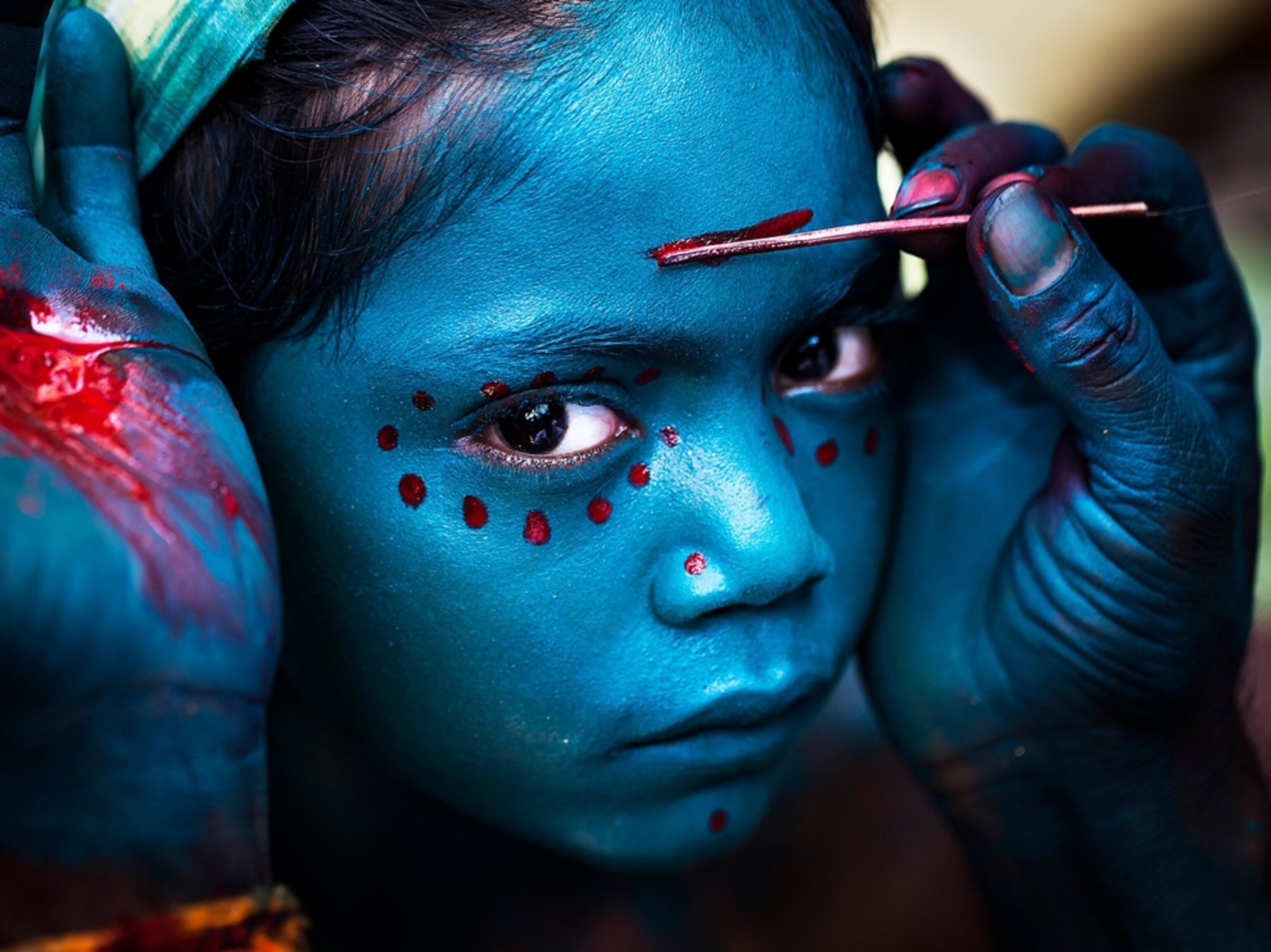 a young girl with blue makeup for a festival in India