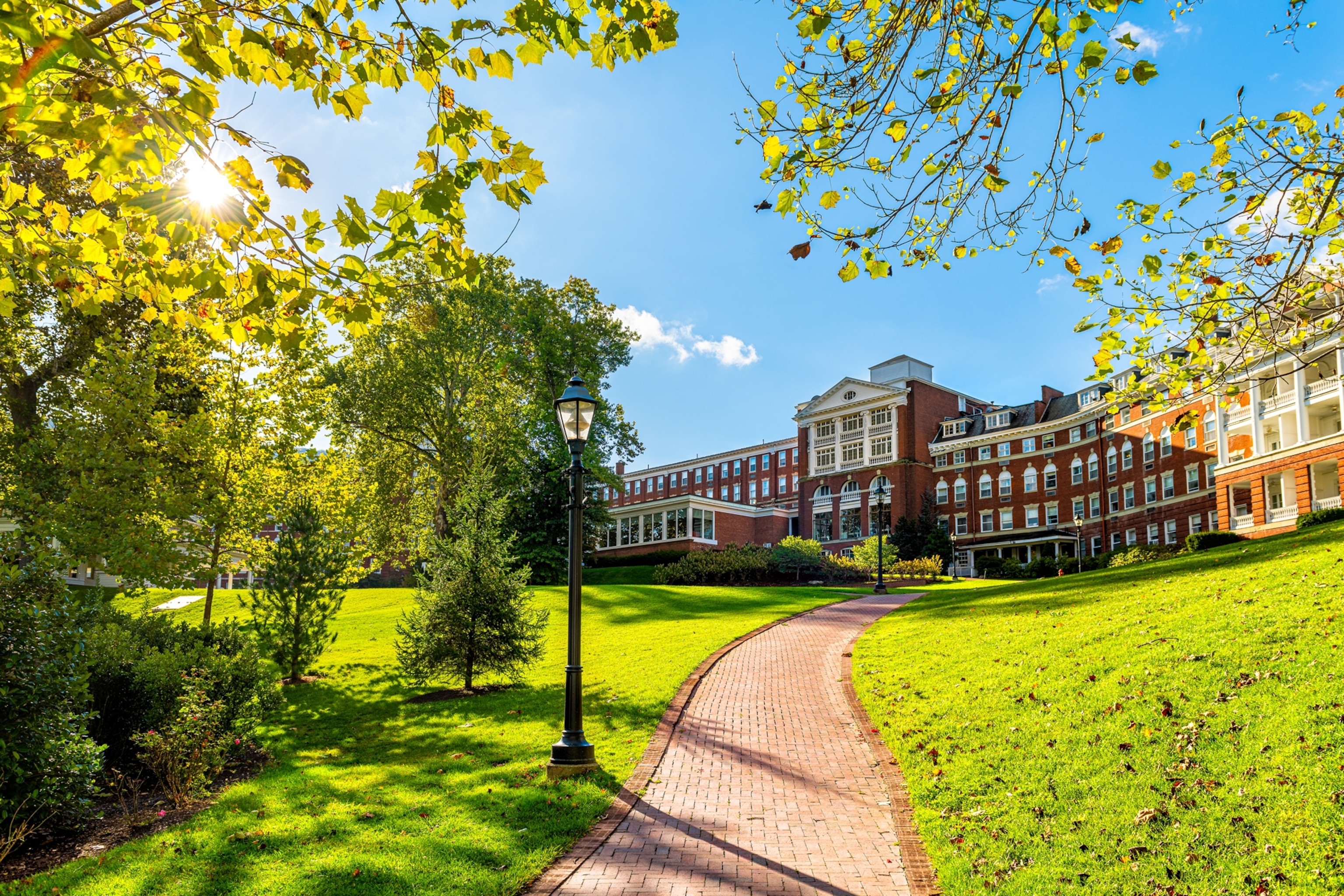 Omni Homestead brick architecture hotel in downtown town village city in Virginia countryside with green grass lawn and path