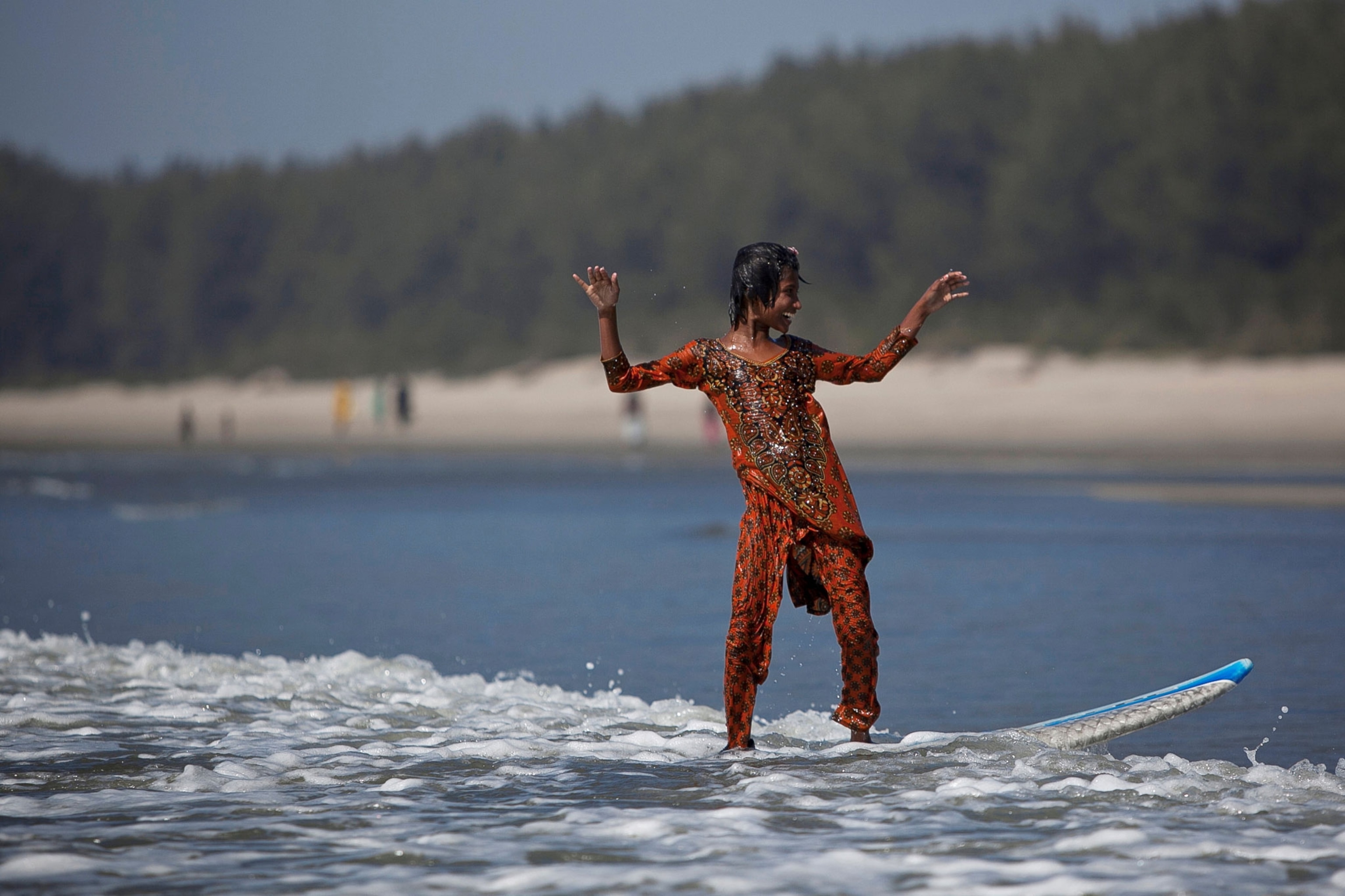 Johanara, 10, surfs during a break from selling chips in Cox's Bazar.