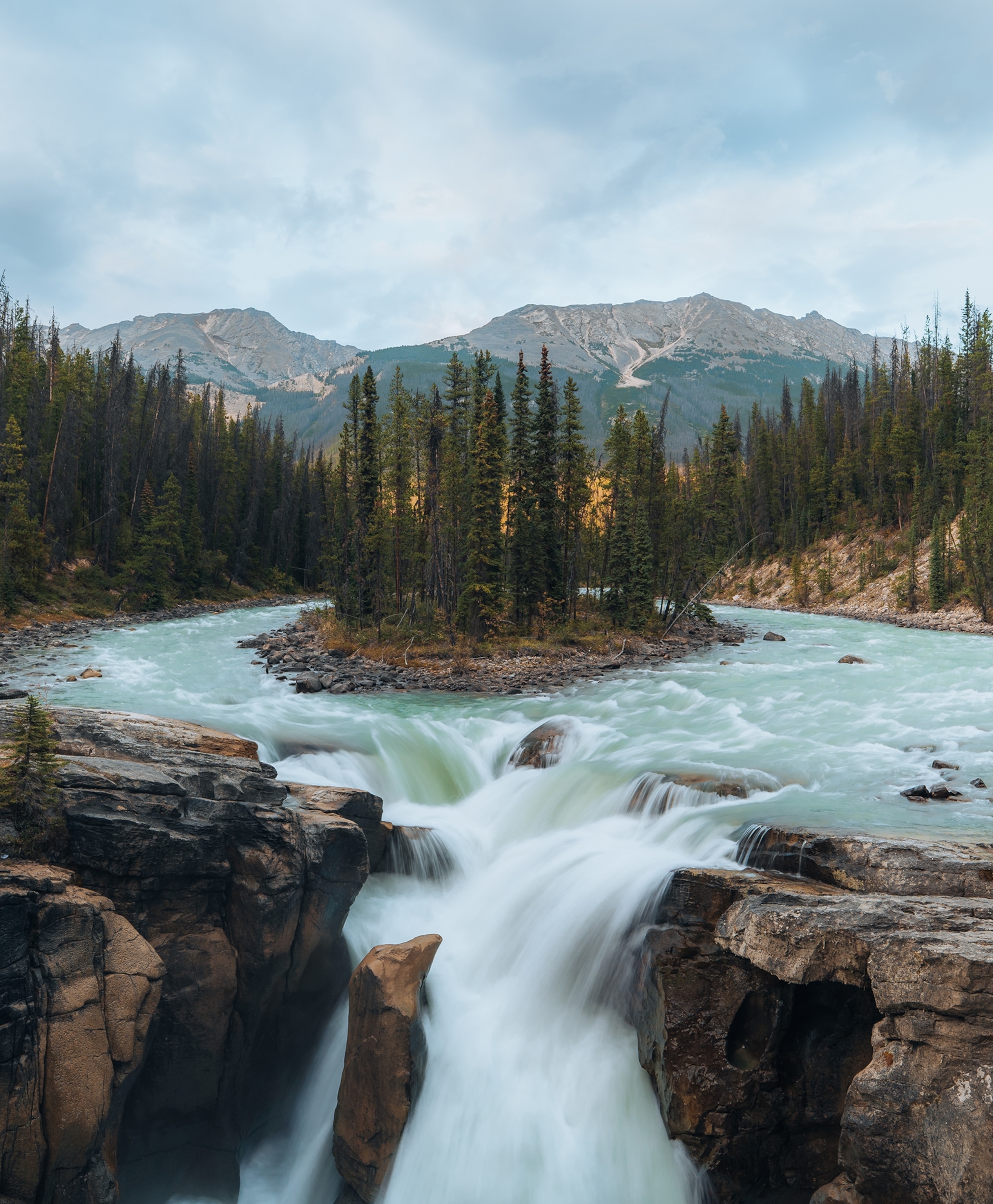 The rushing current of the Sunwapta River cascades into the Sunwapta Falls in Jasper National Park. I captured this image on the second day of my three-day Canadian Rockies expedition from Banff to Jasper. I didn’t know about this spot, but a kind woman saw me with my camera and recommended it.