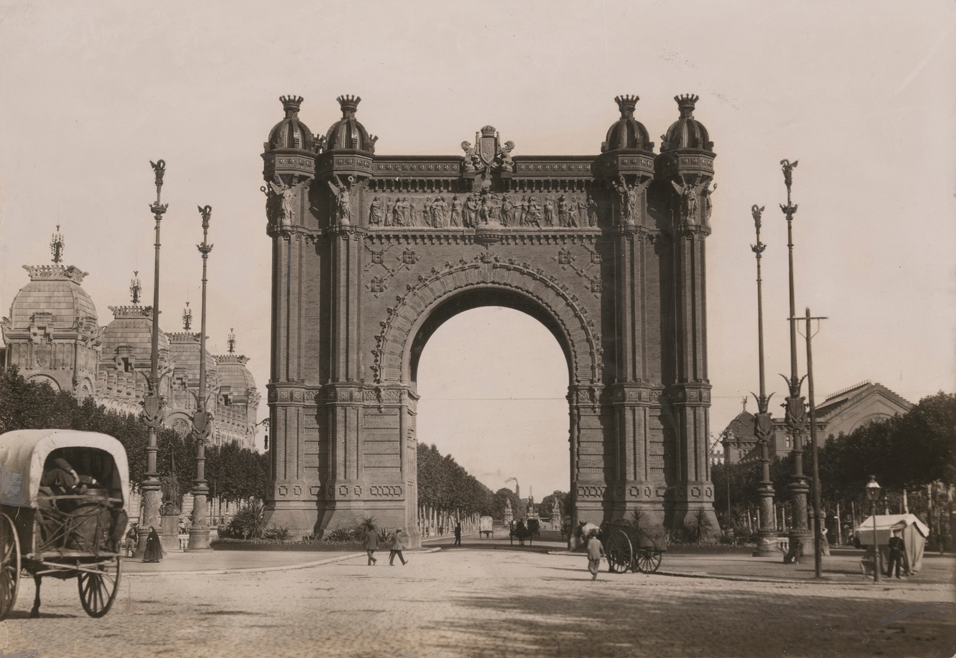 Various pedestrians walk by an arch of triumph from the 1888 universal exposition.
