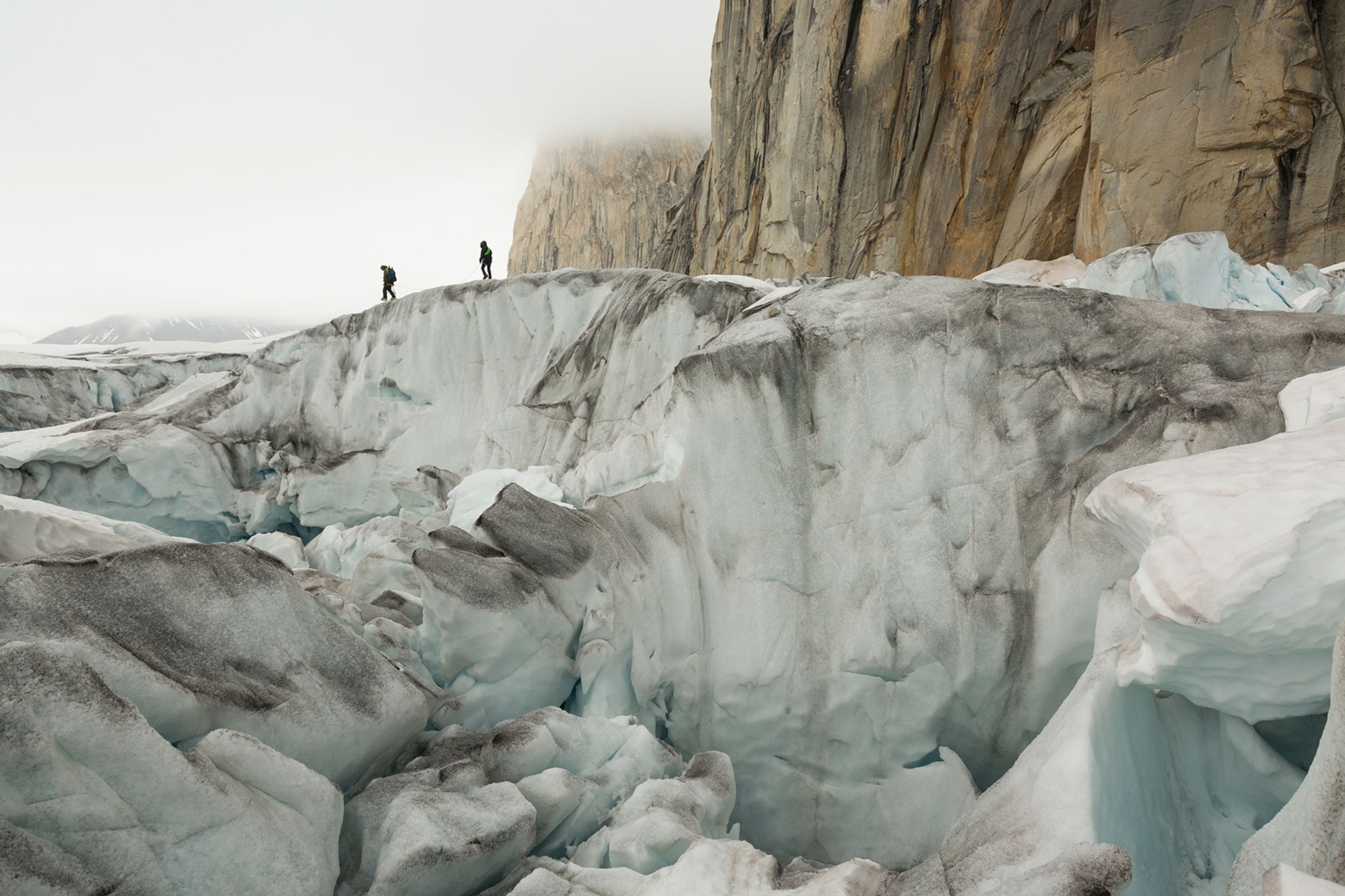 climbers skiing across snow bridges through icefalls in the Upper Ruth Glacier