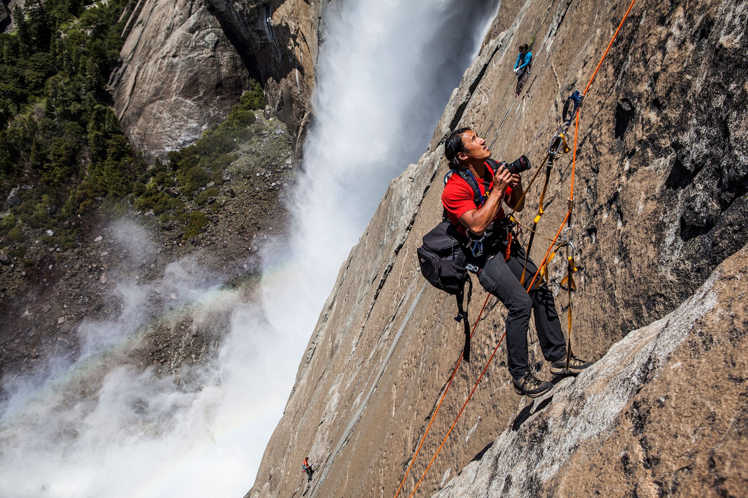 Jimmy Chin photographing from a rope beside Yosemite Falls
