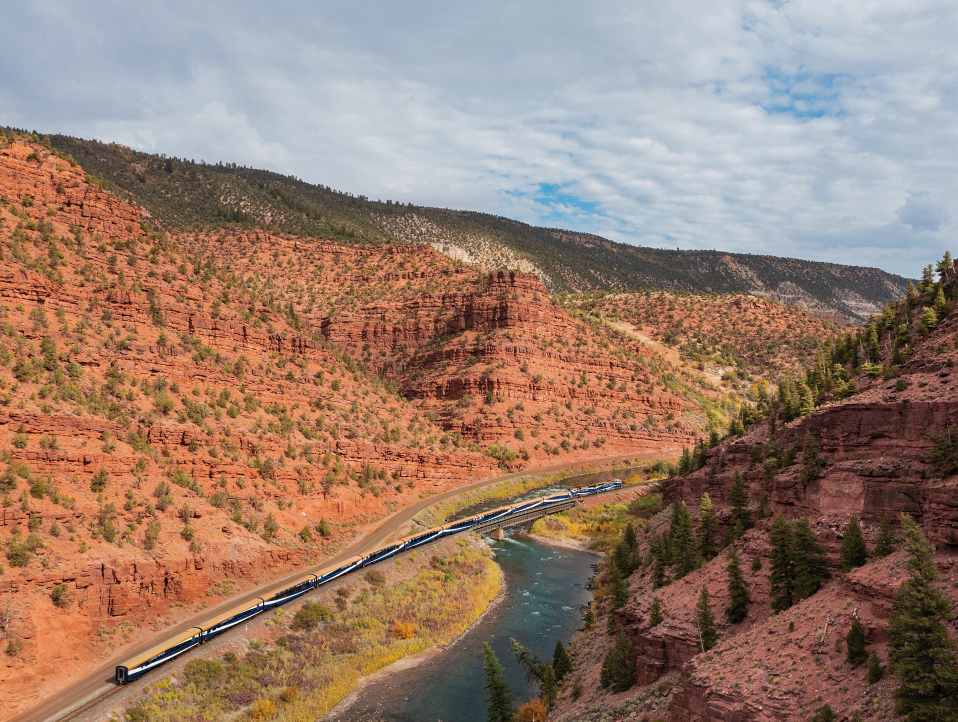 A train heads through narrow rocky mountains