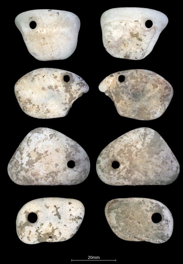 two rows of pendants with a piercing in them against a black backdrop