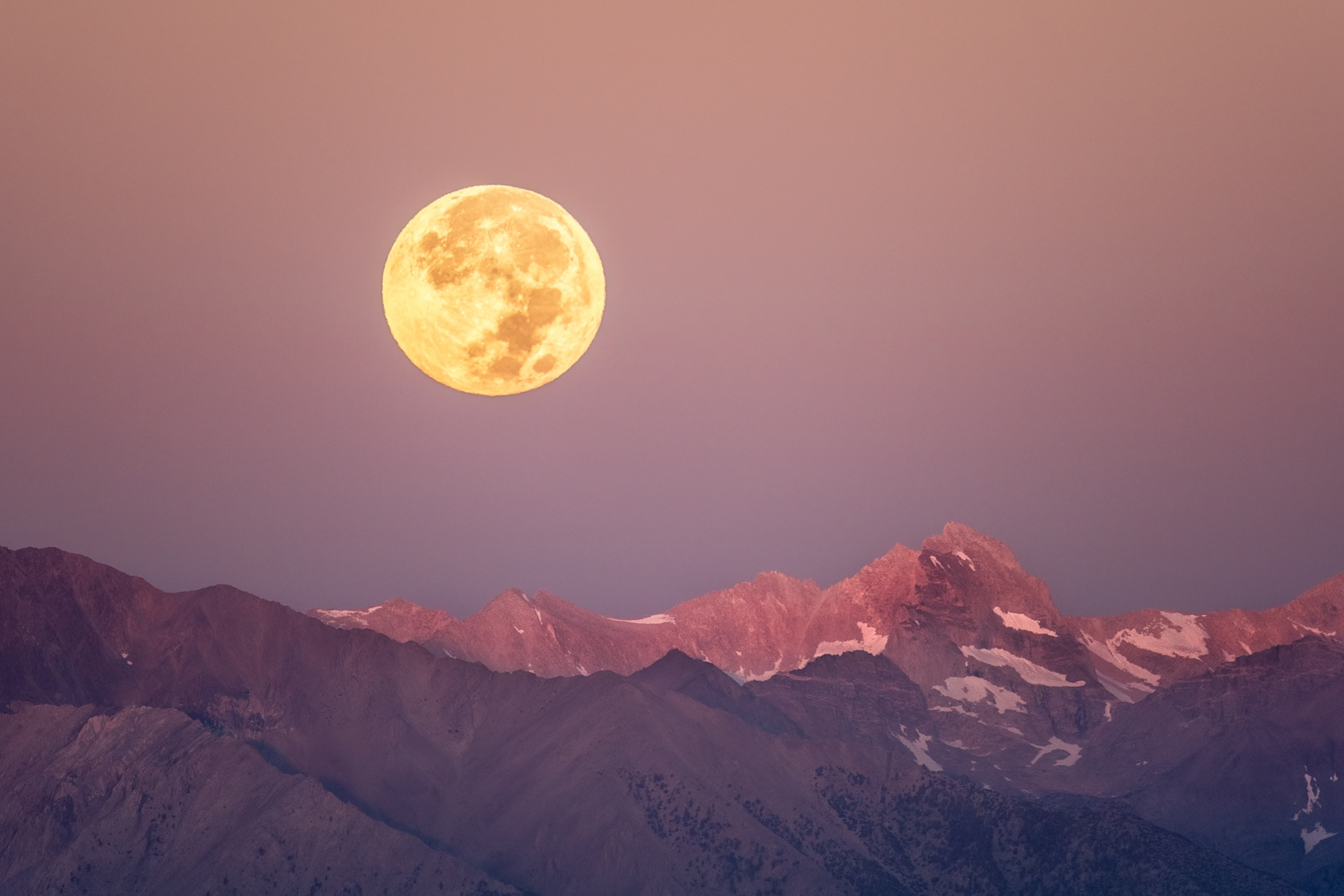 Full moon setting over the Eastern Sierra Mountains during sunrise.