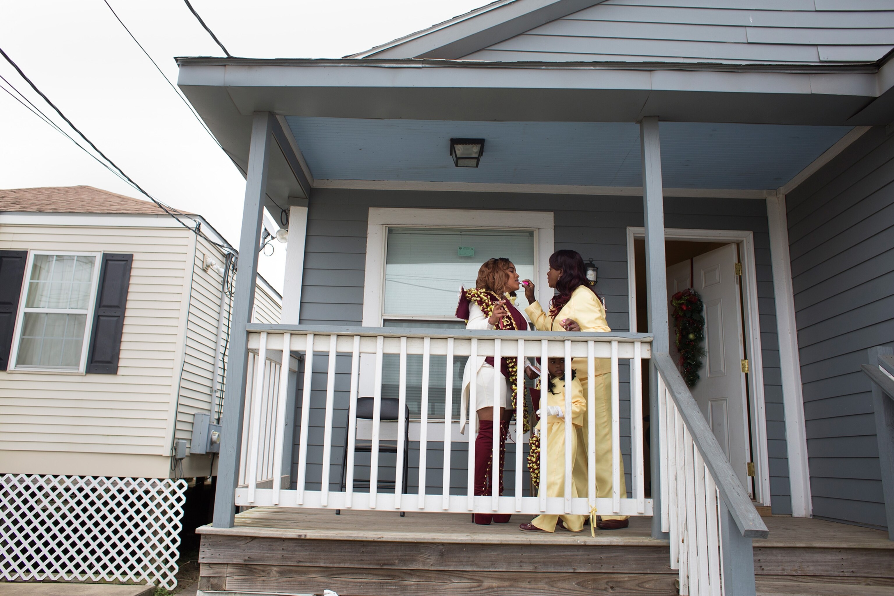 Kenya Waterhouse gets some help with her lipstick from close friend and fellow Big Nine member, Sally Jones on the porch of her Lower Ninth Ward home in New Orleans.