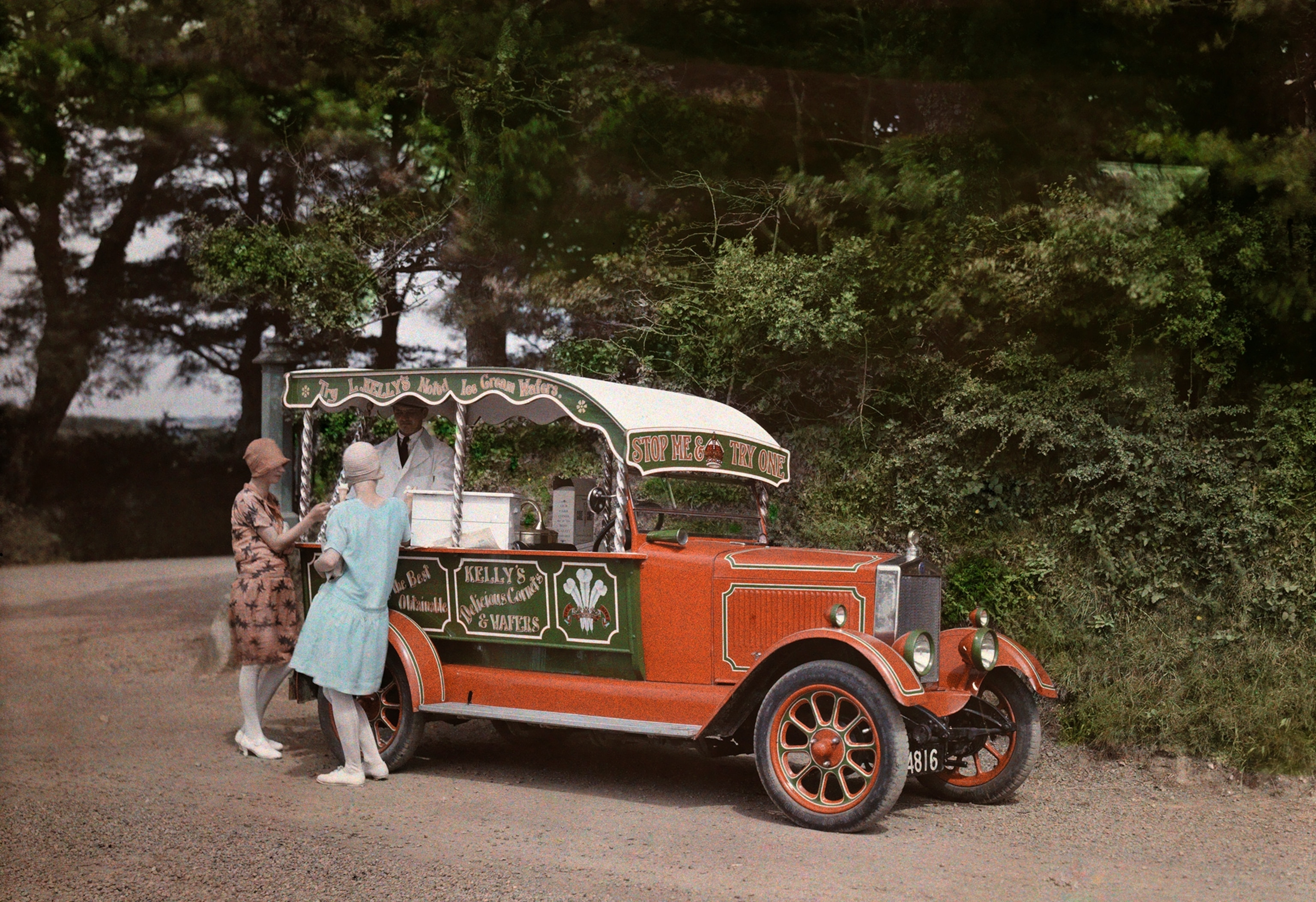 Two women buy ice cream from a vendor out of his converted car.